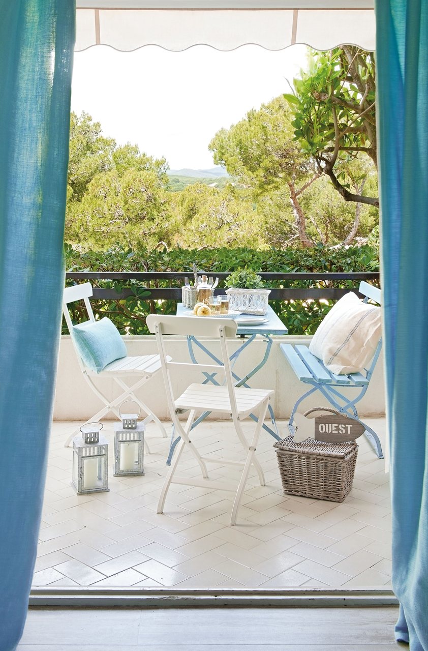 Terraza pequeña con muebles plegables en blanco y azul.