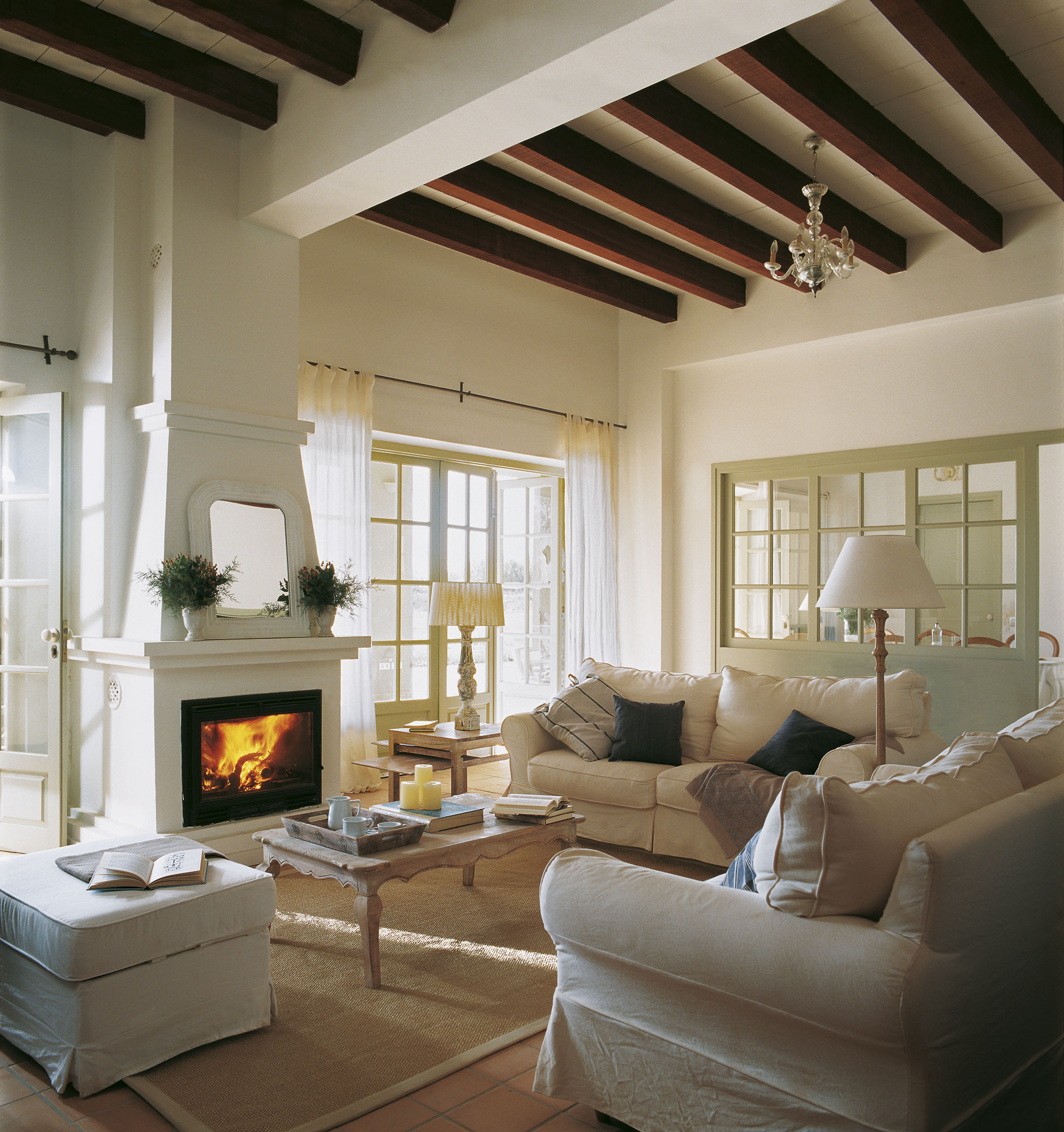 Salón clásico con sofás de color blanco y chimenea. 