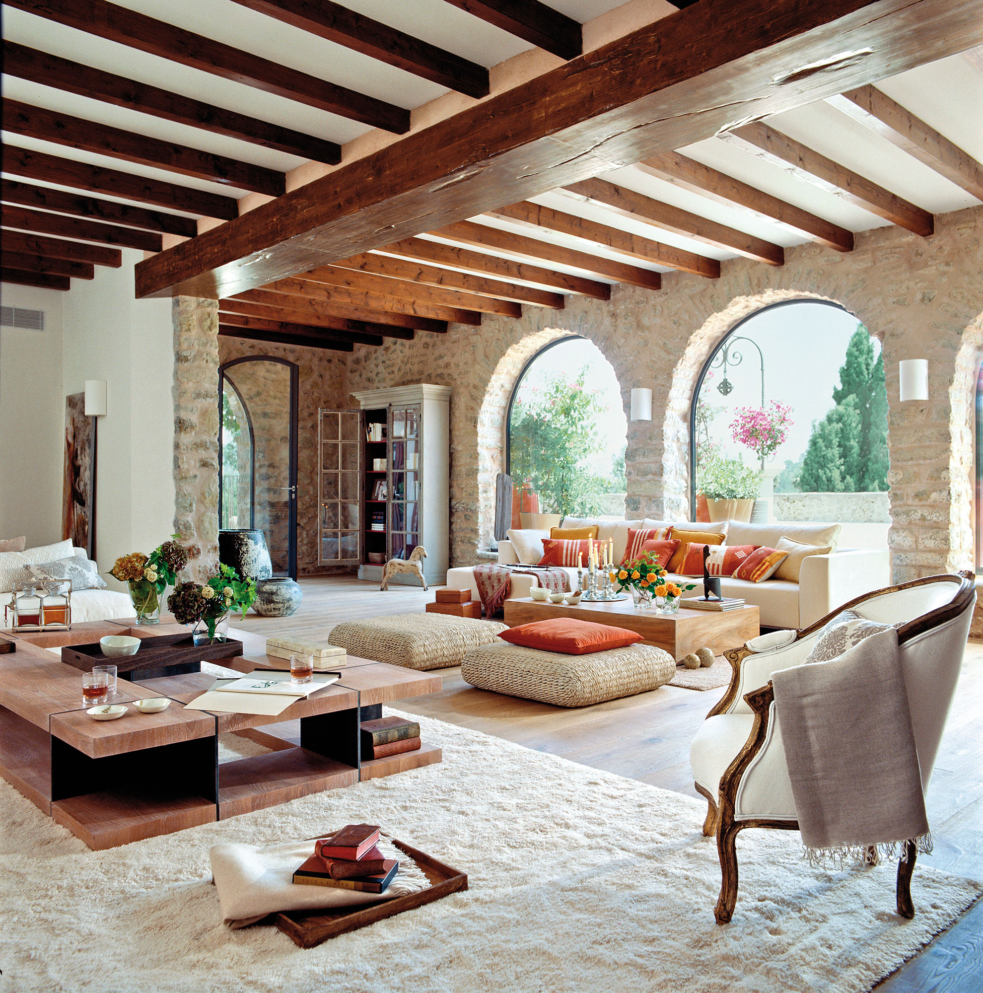 Salón rústico con paredes de piedra y techos con vigas de madera. 
