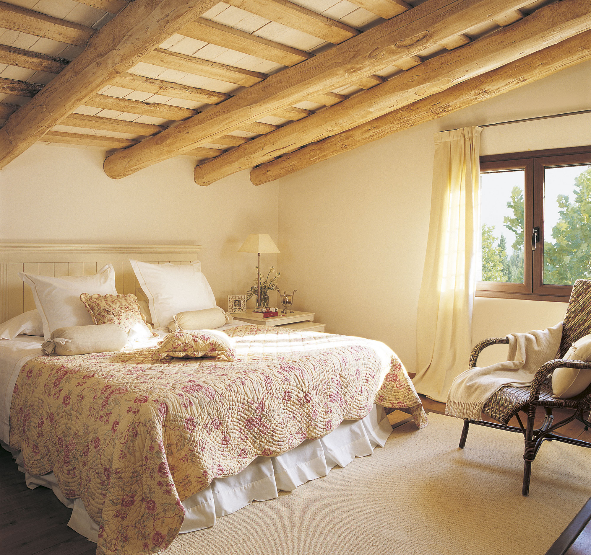 Dormitorio con techo de madera y boutí de flores. 