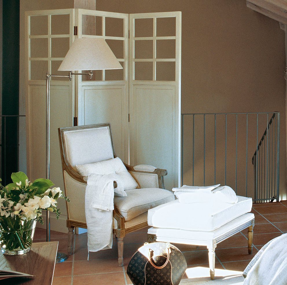 Dormitorio con biombo, butaca y banqueta en tonos blancos