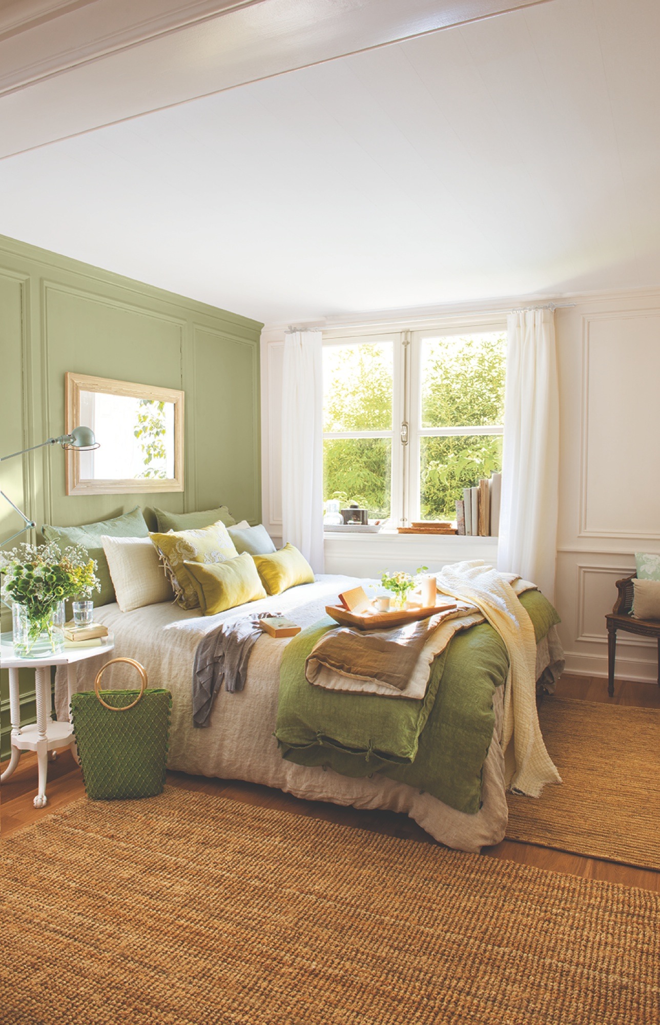 Dormitorio con pared con molduras pintada de verde. 