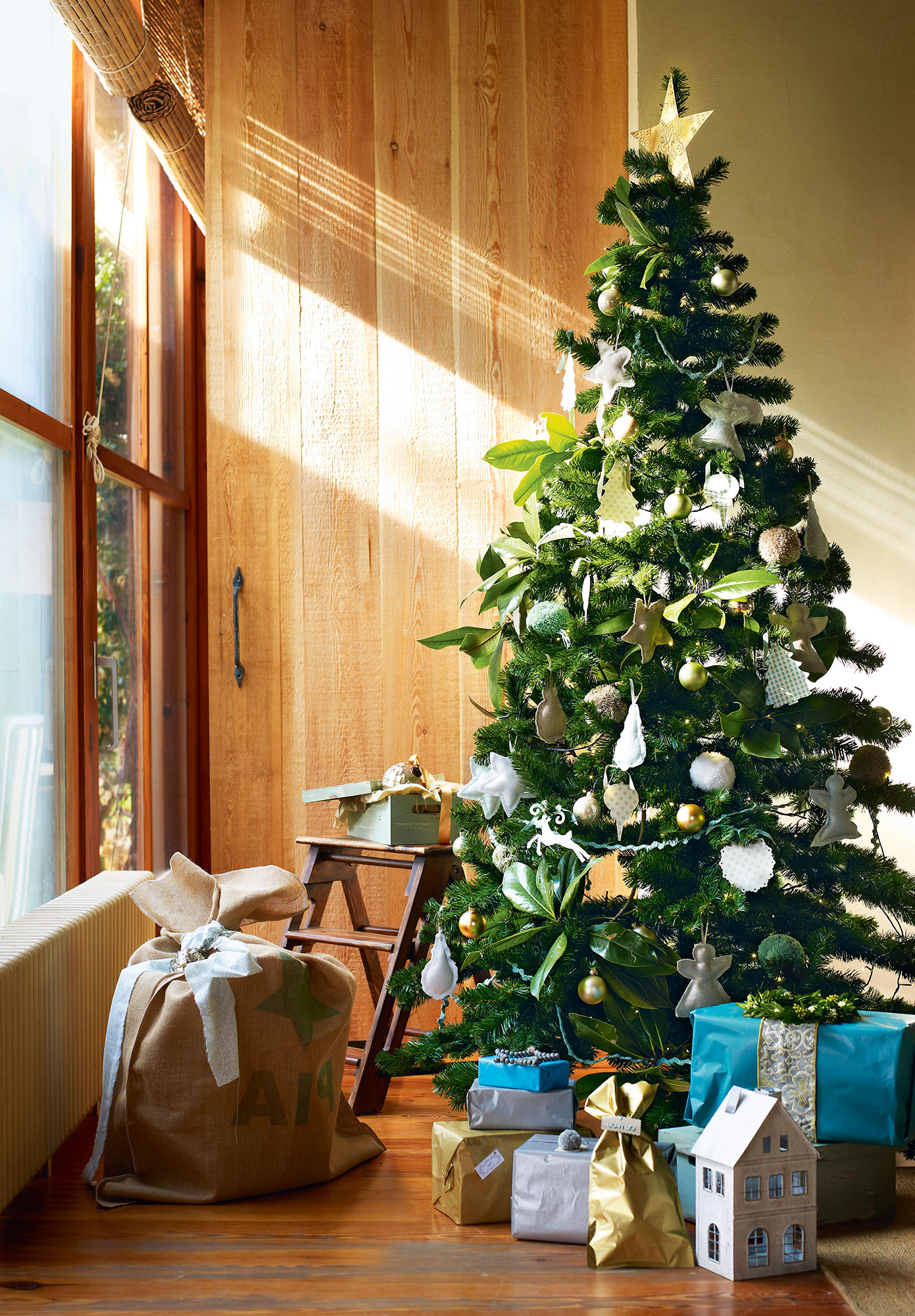Rincón decorado con un árbol de Navidad y regalos. 