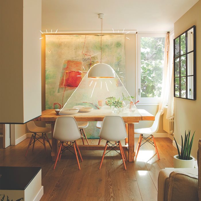Comedor con gran cuadro iluminado, mesa rectangular de madera  y lámpara de techo