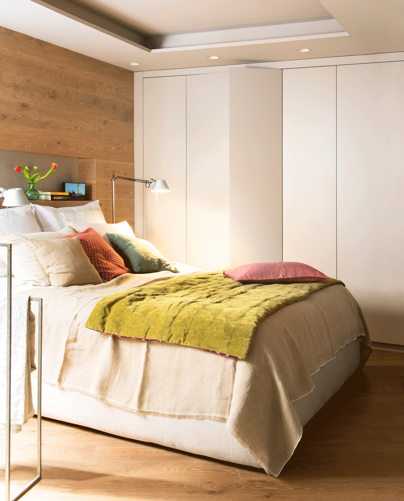 Dormitorio moderno con pared del cabecero revestida en madera.