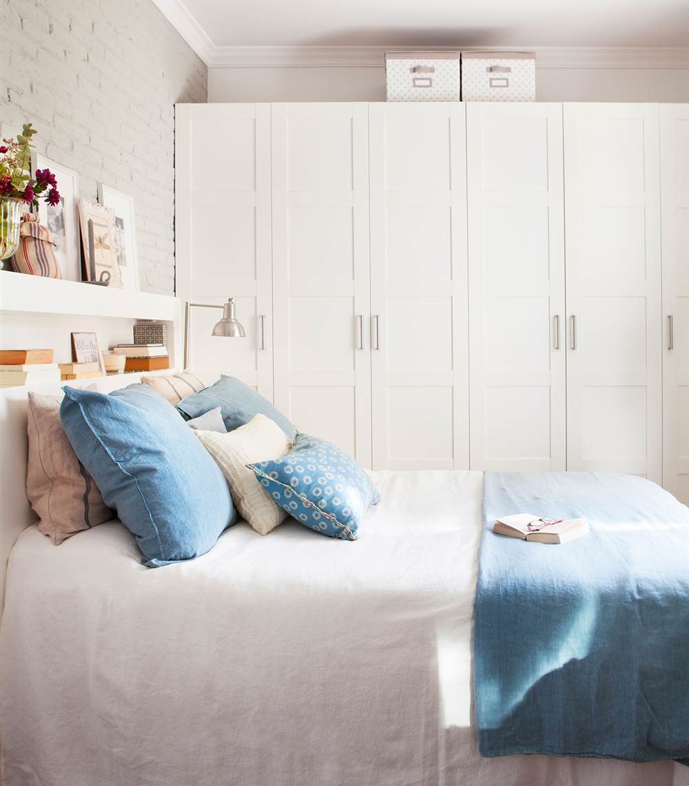 Dormitorio con gran armario y cabecero en blanco y pared de ladrillos vista en gris