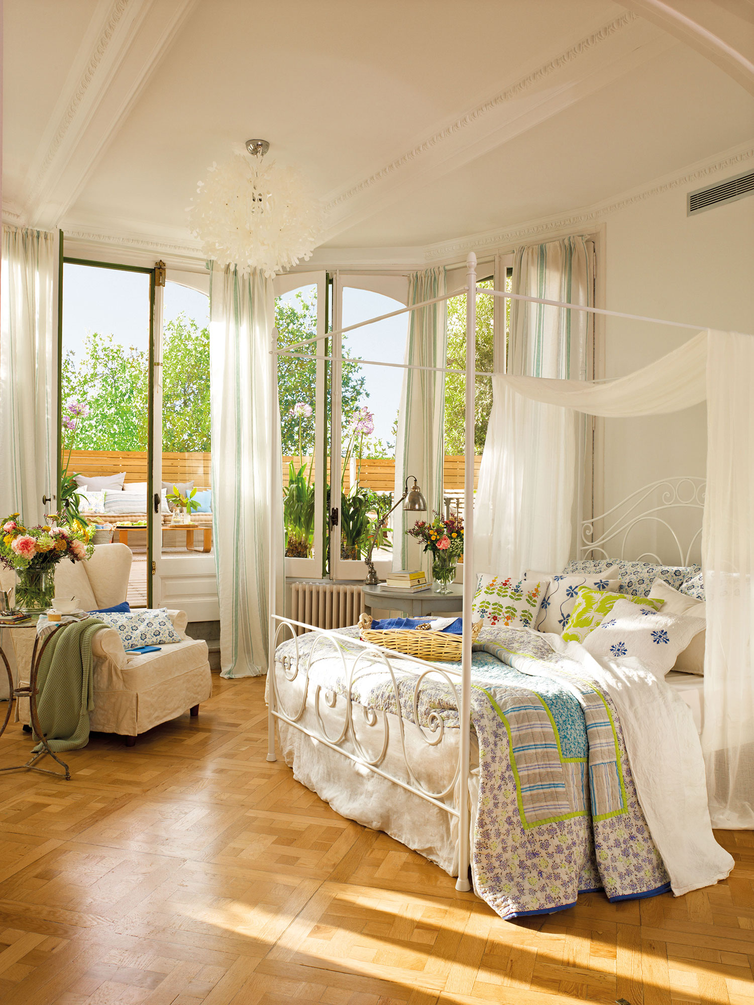 Dormitorio de verano con cama con dosel y ropa de cama floral. 