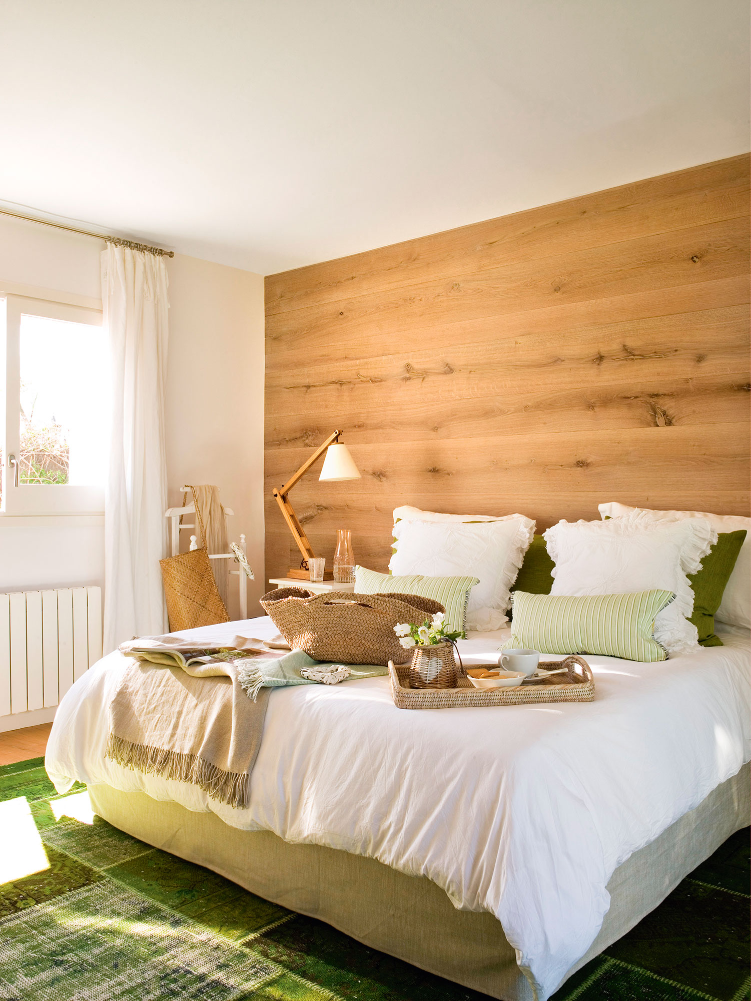 Dormitorio de verano con pared de madera en el cabecero. 