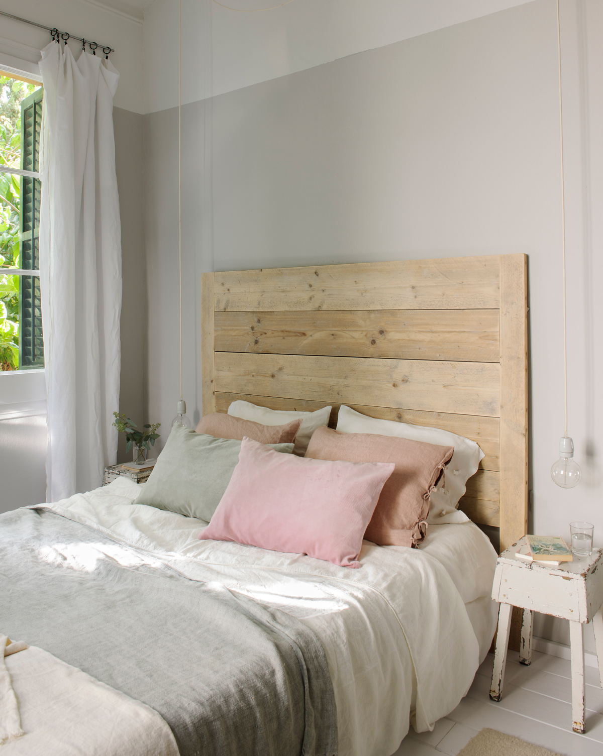Dormitorio decorado en tonos neutros con cabecero de madera.