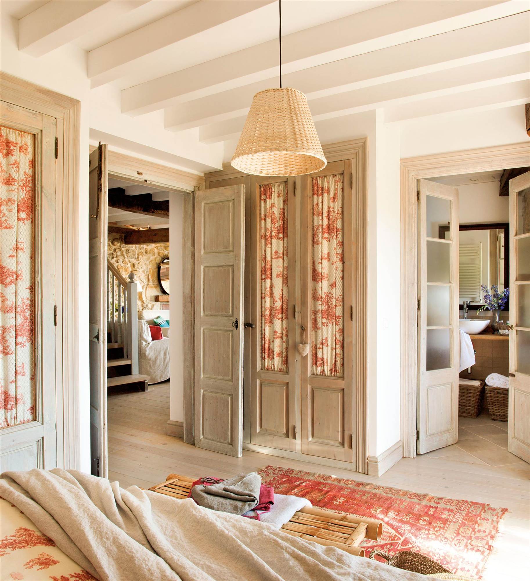 Dormitorio rústico con armarios con frentes acristalados y con cortinillas de toile de Jouy