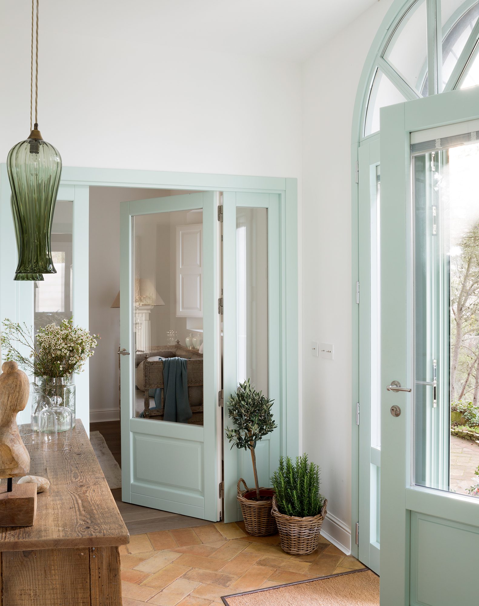 Recibidor de una casa de estilo clásico con una puerta en n verde candy.