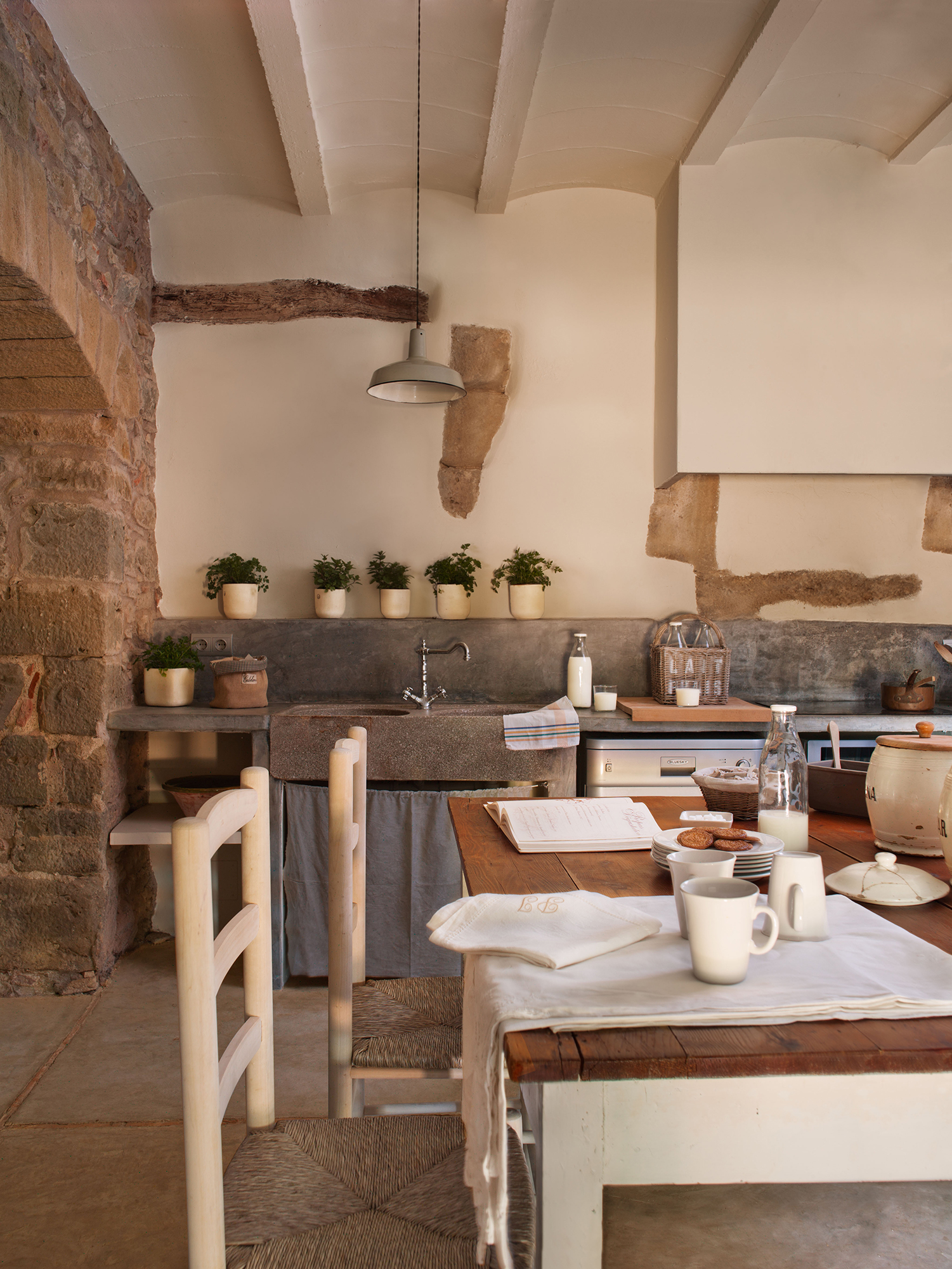 Cocina de casa de campo antigua con paredes de piedra y office. 