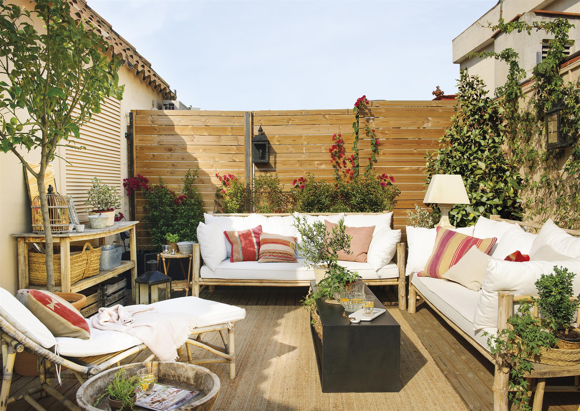 Terraza con paneles de madera y sofás con estructura de madera y asientos en blanco. 