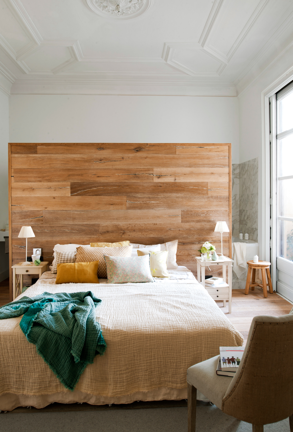 Dormitorio regio con murete revestido de lamas de madera que separa del baño