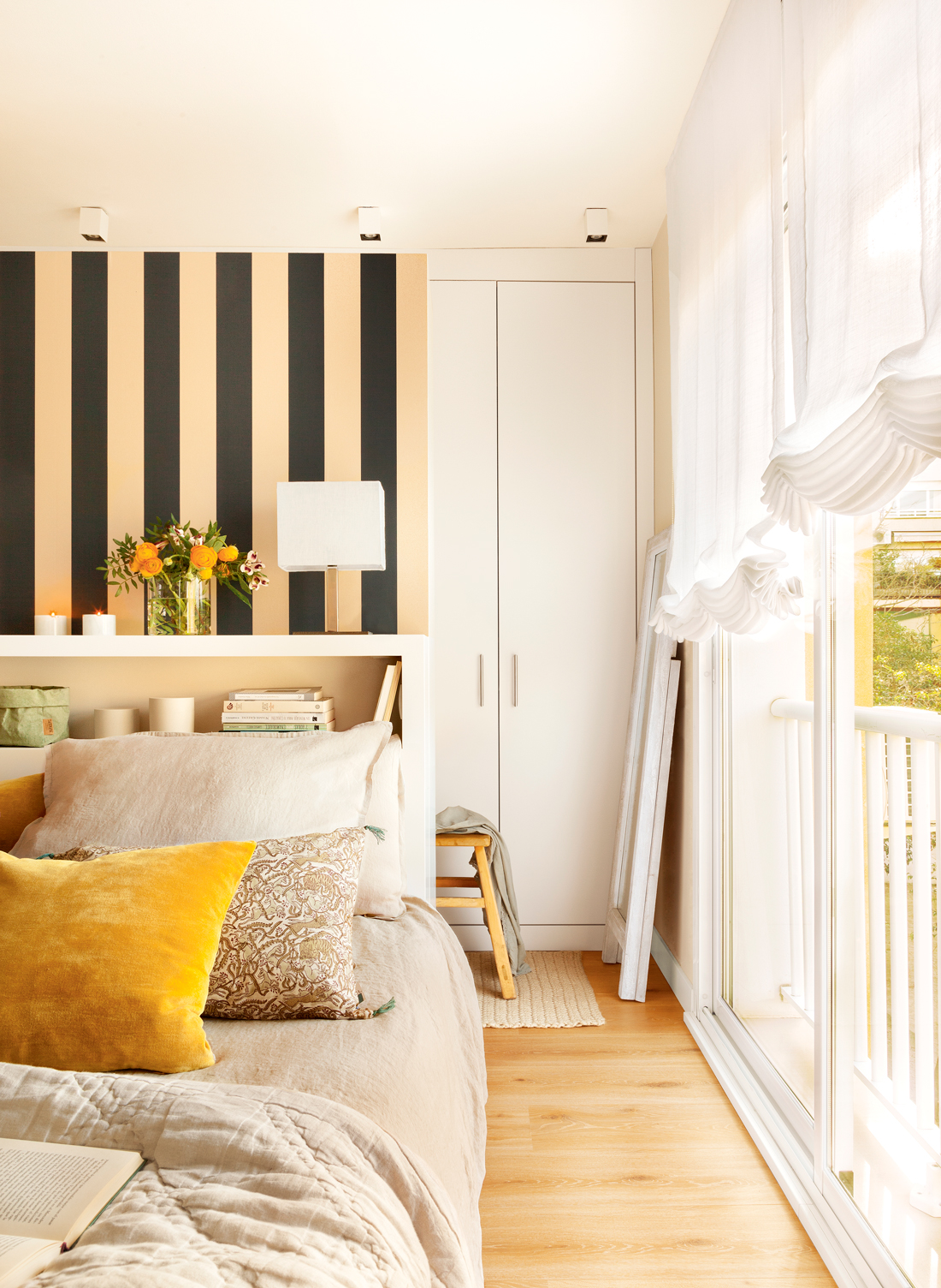 Dormitorio con murete que separa del vestidor revestido con papel pintado bicolor