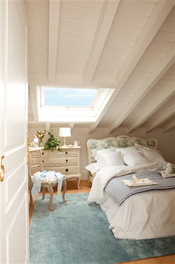 Dormitorio abuhardillado blanco con cabecero tapizado