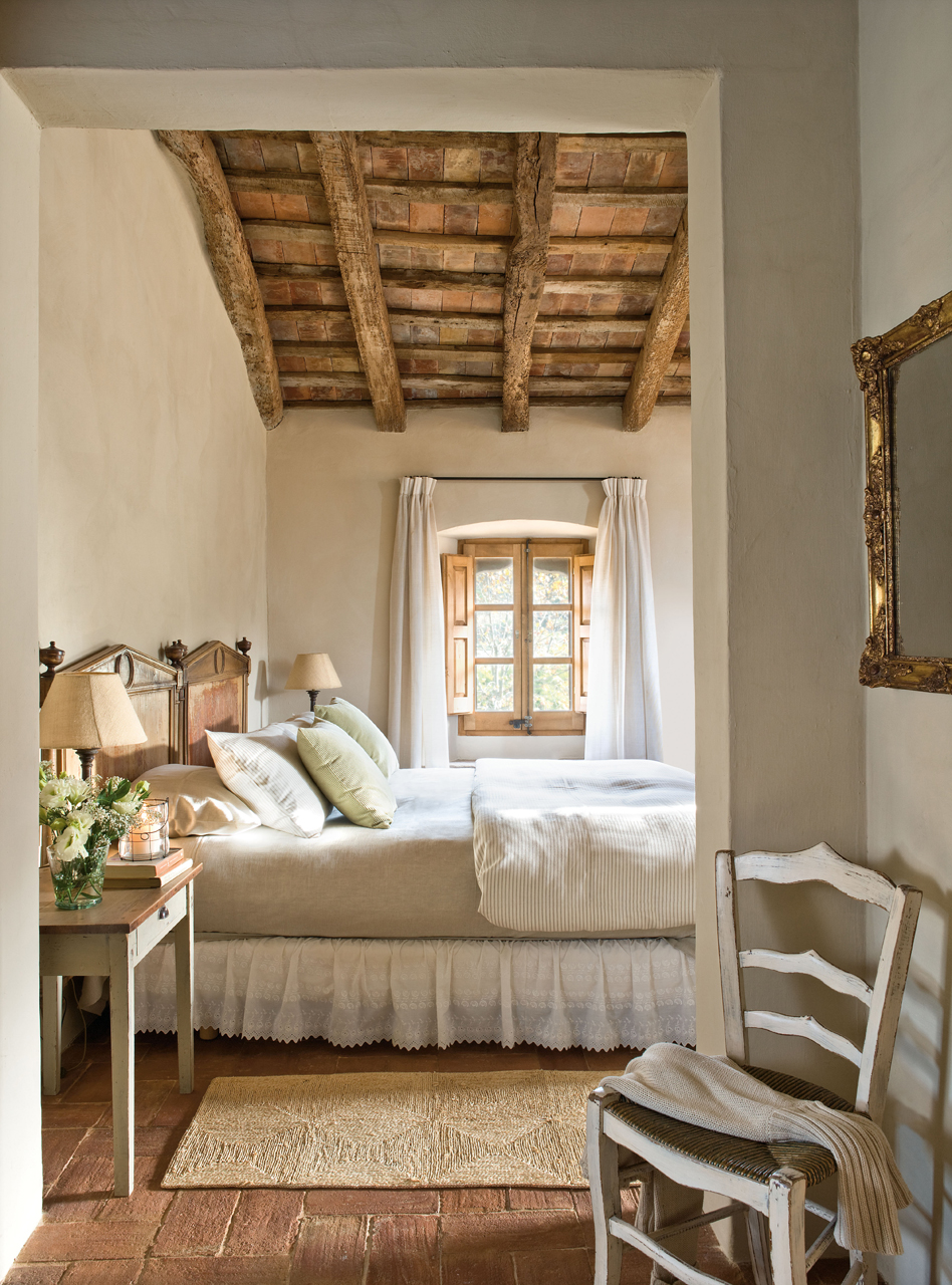 Dormitorio rural con vigas de madera 