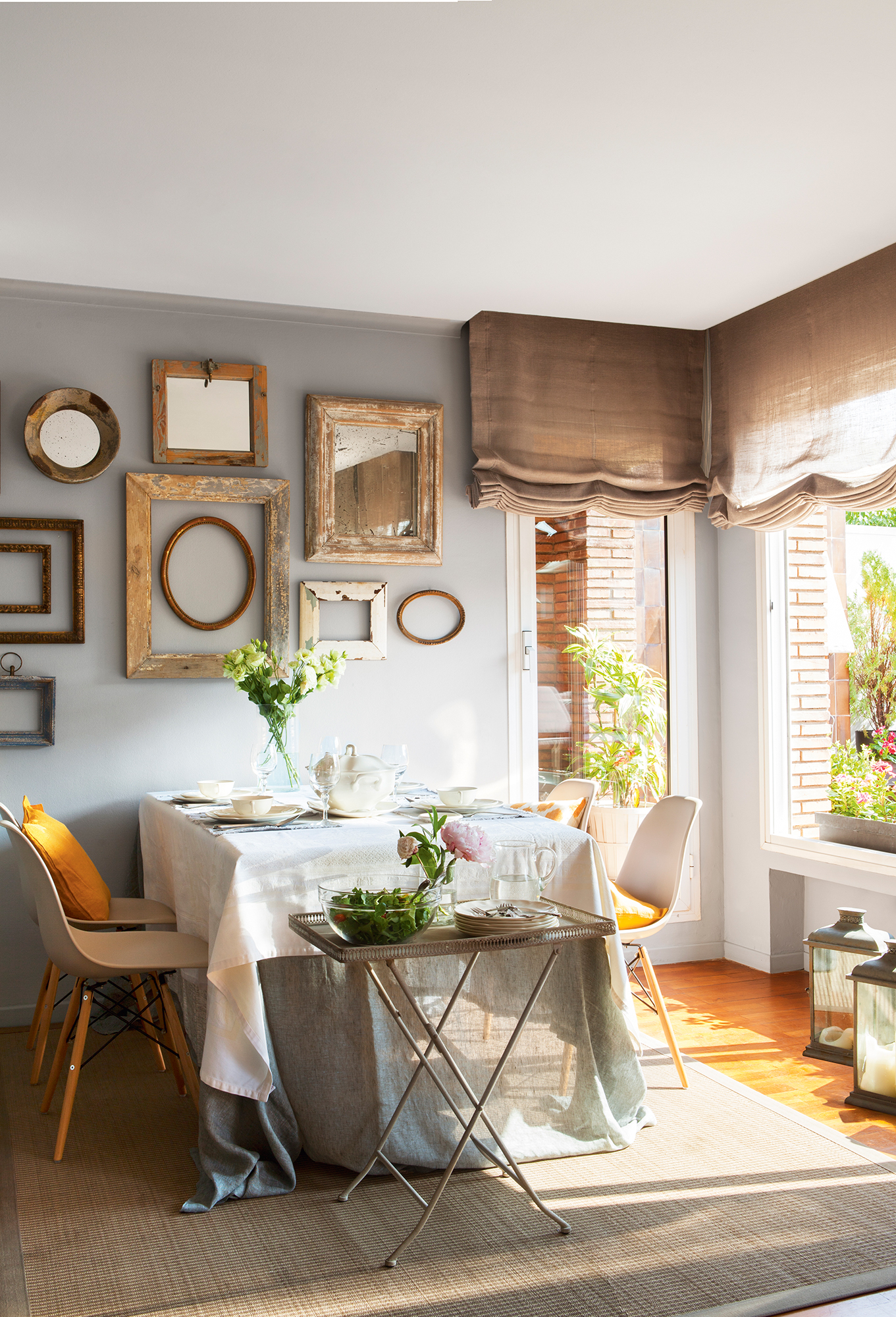 Comedor con paredes en gris decoradas con marcos de varios tamaños y acabados. 