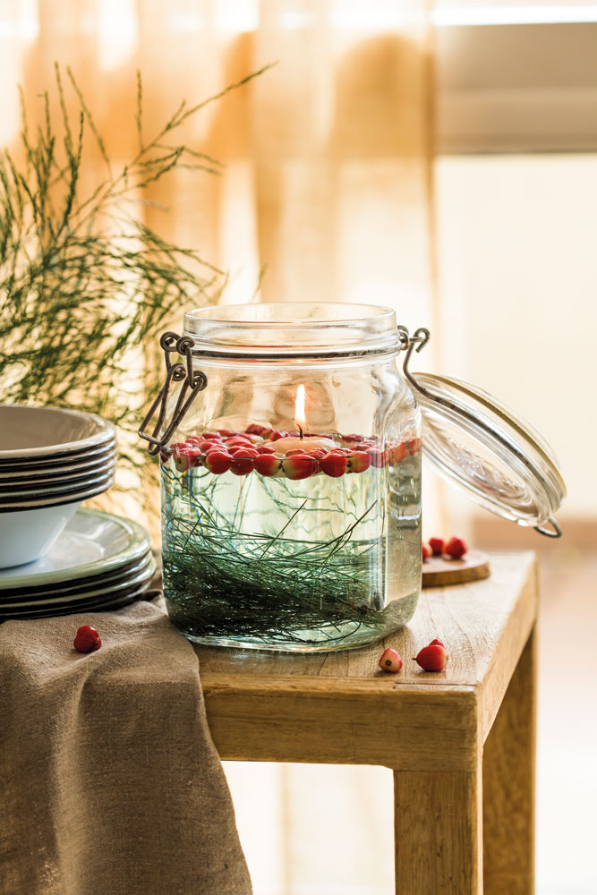 Jarra de cristal con agua, frutas y una vela