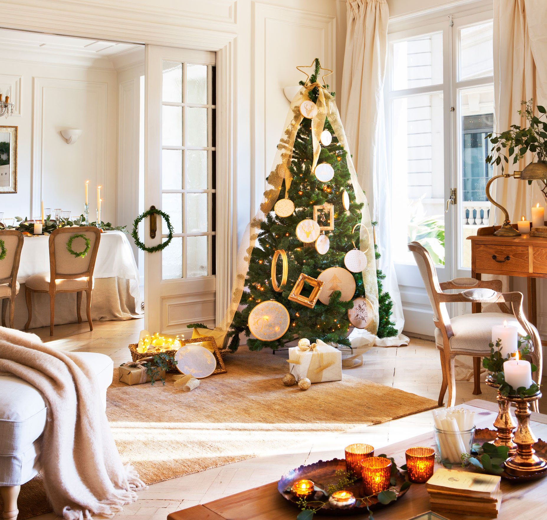 Salón comedor clásico con puerta acristalada, alfombra y árbol de Navidad al lado de la ventana con adornos dorados. 
