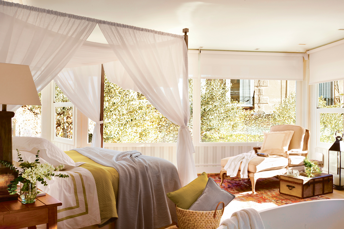 Dormitorio clásico con cama con dosel y chaise longue. 