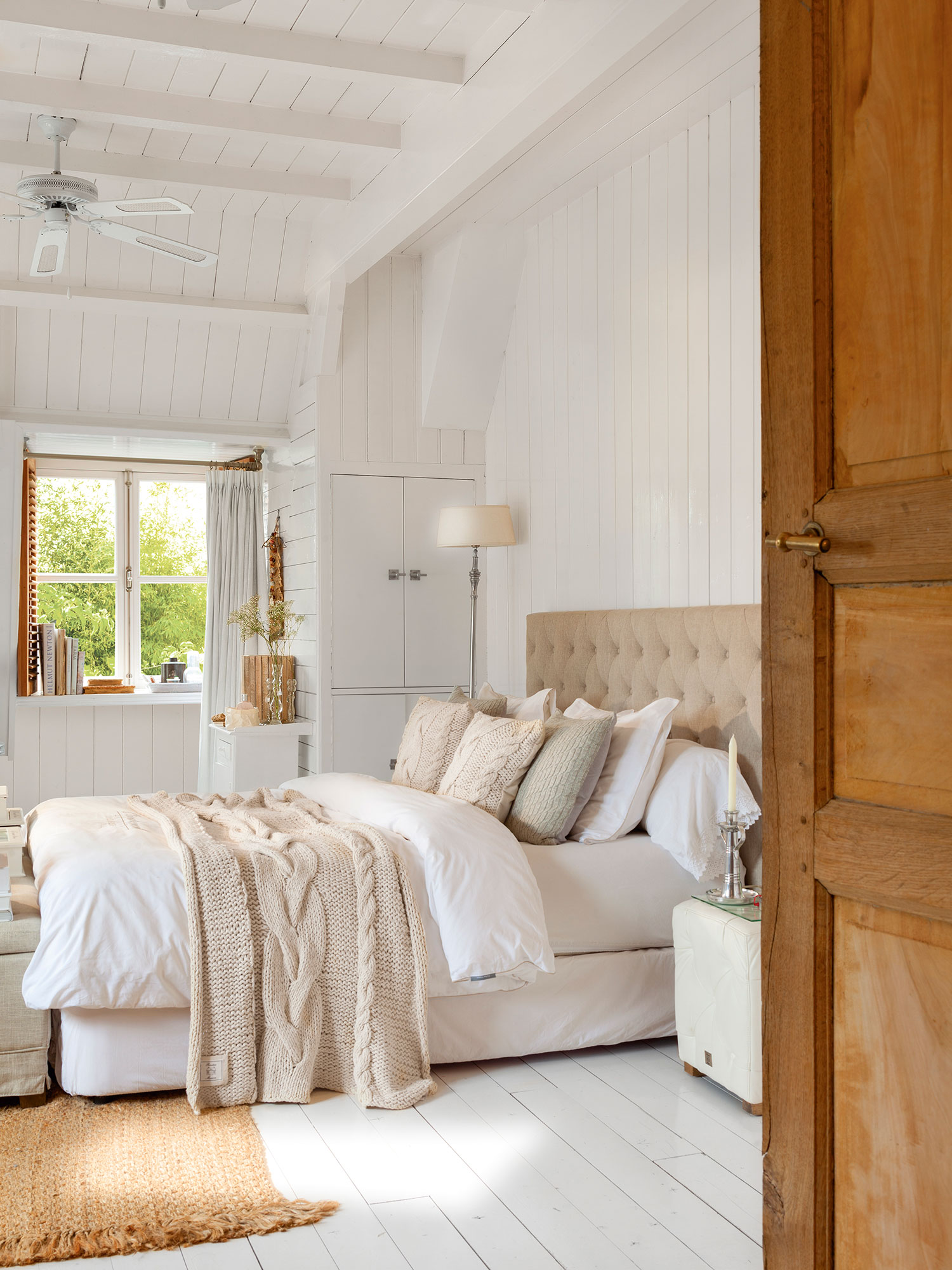 Dormitorio principal de estilo nórdico con cabecero alcolchado. 