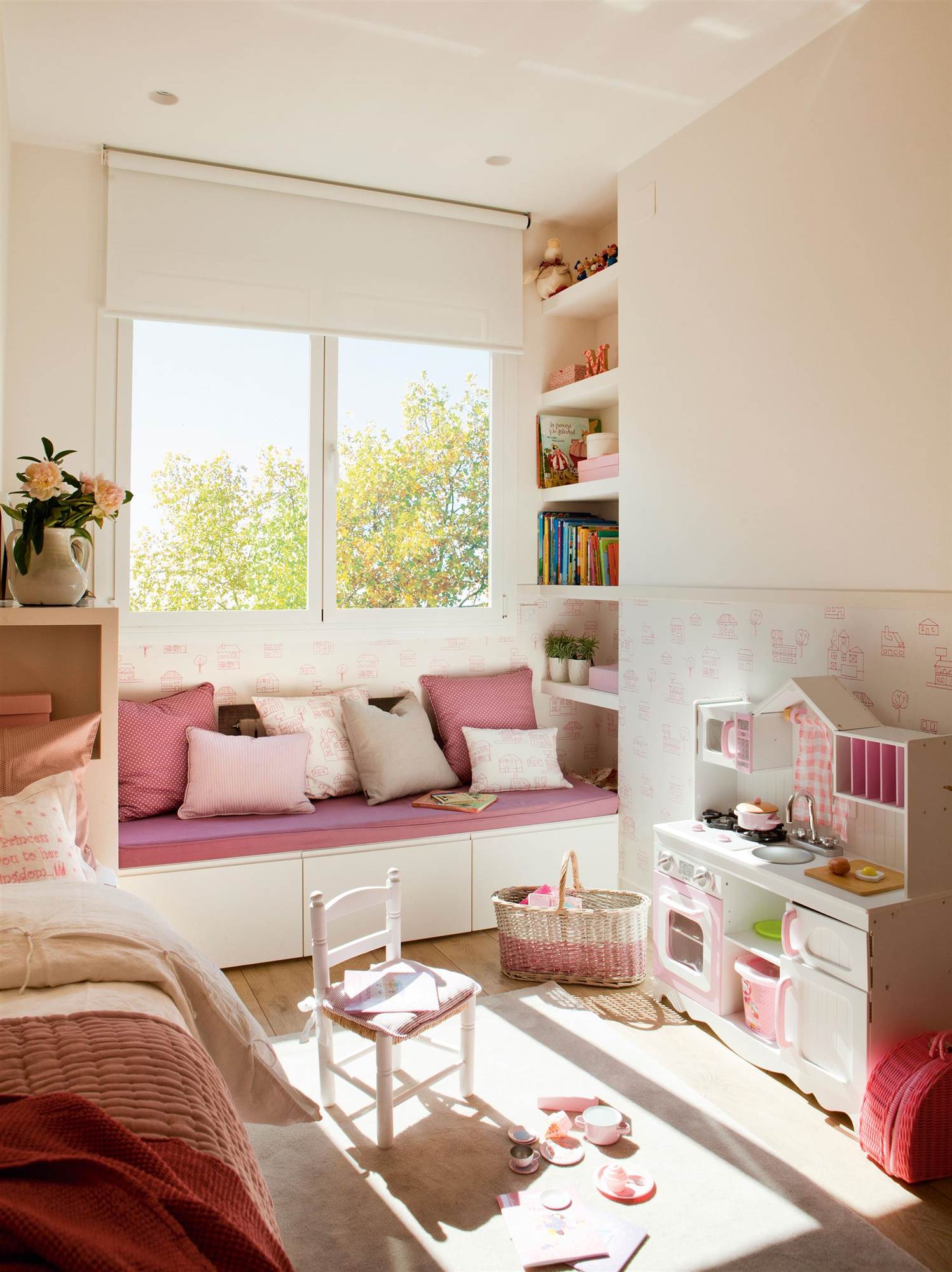 Dormitorio infantil en rosa con banco bajo la ventana, decorado por Elena Rodríguez.  
