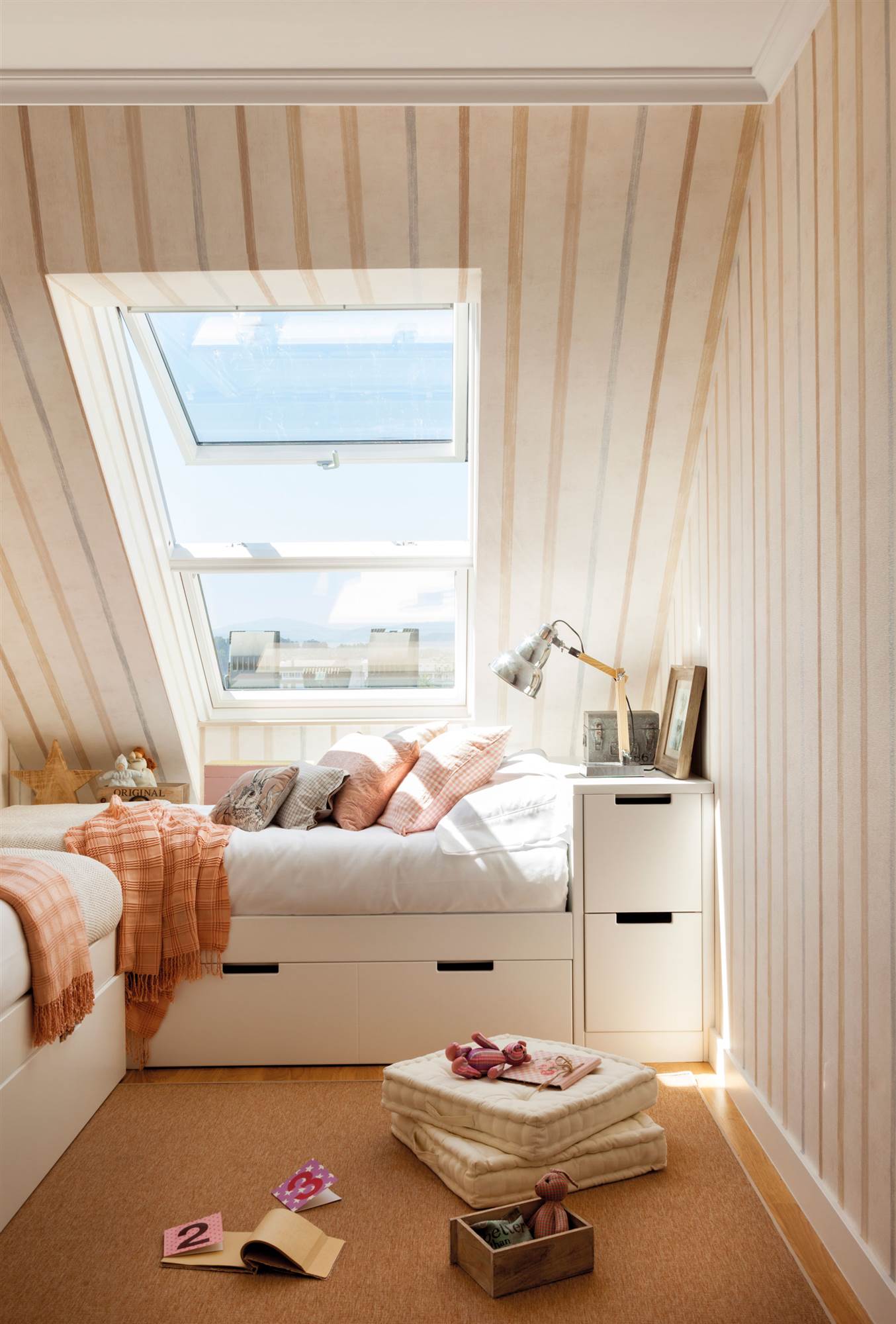 Dormitorio infantil con cama nido en L y papel pintado de rayas en las paredes y techos. 