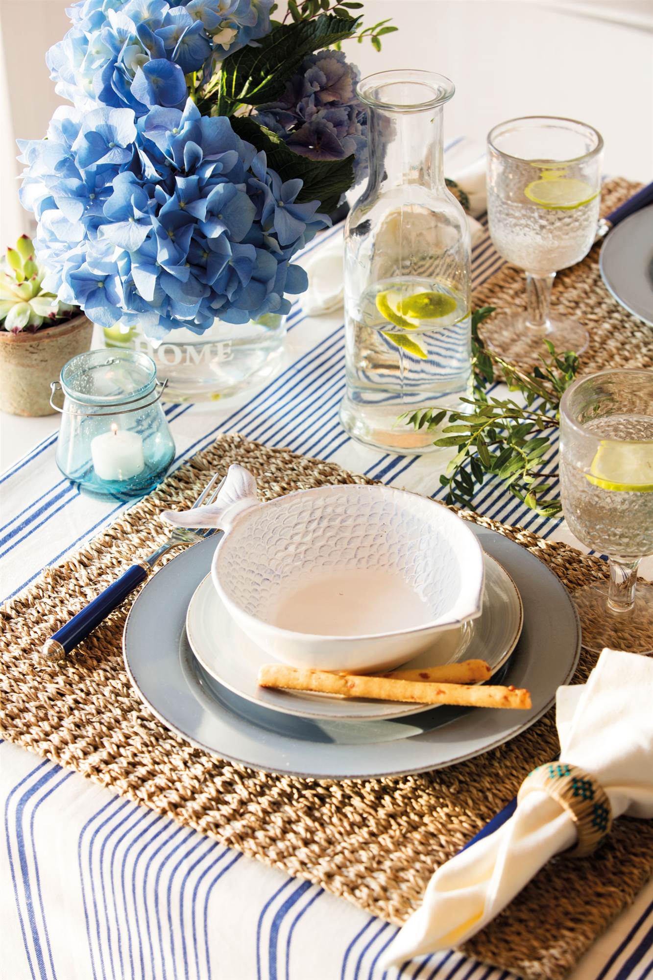 Mesa de comedor con vajilla de estilo marinero. 