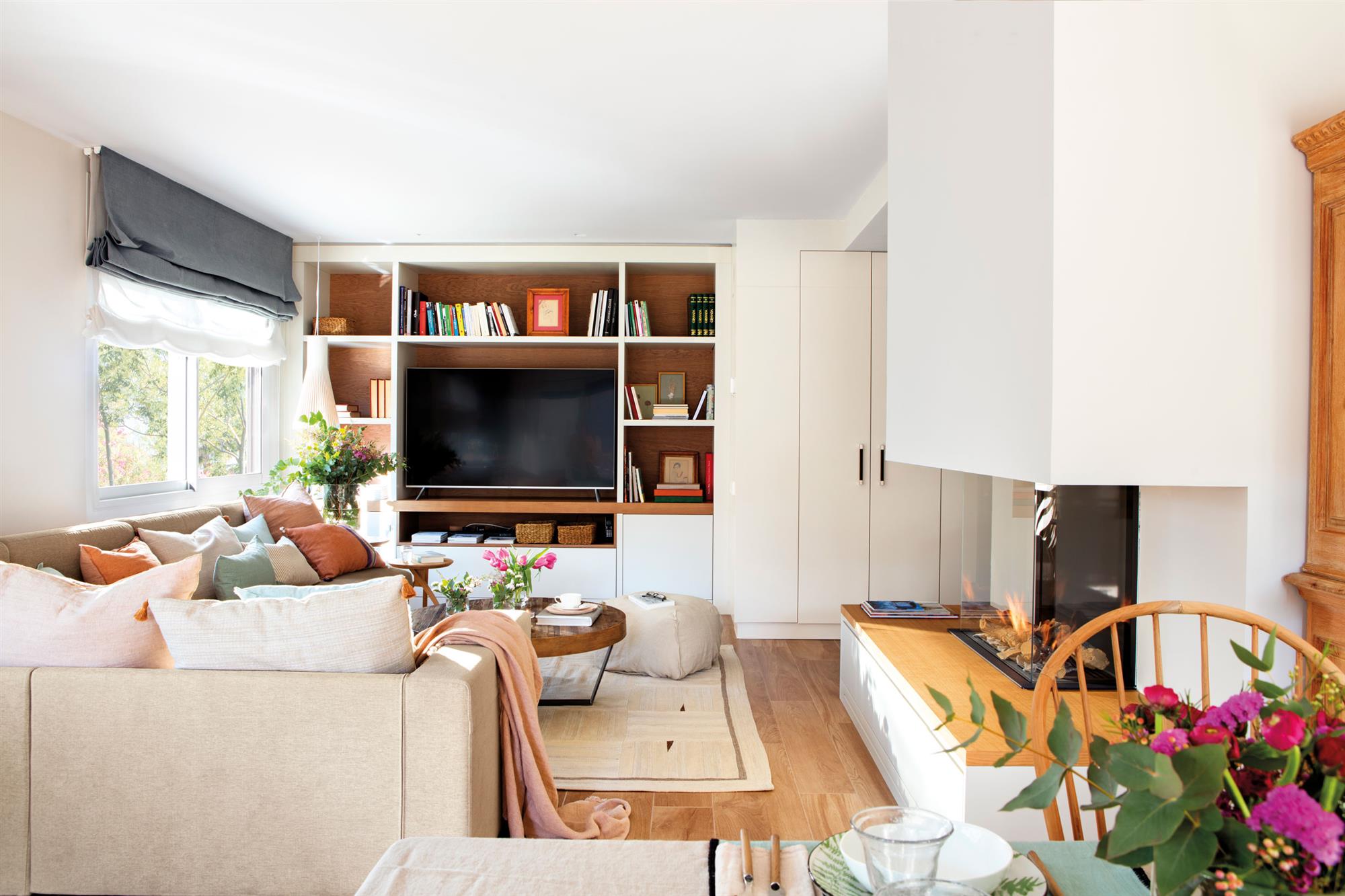 Salón con sofá esquinero beige y chimenea moderna. 