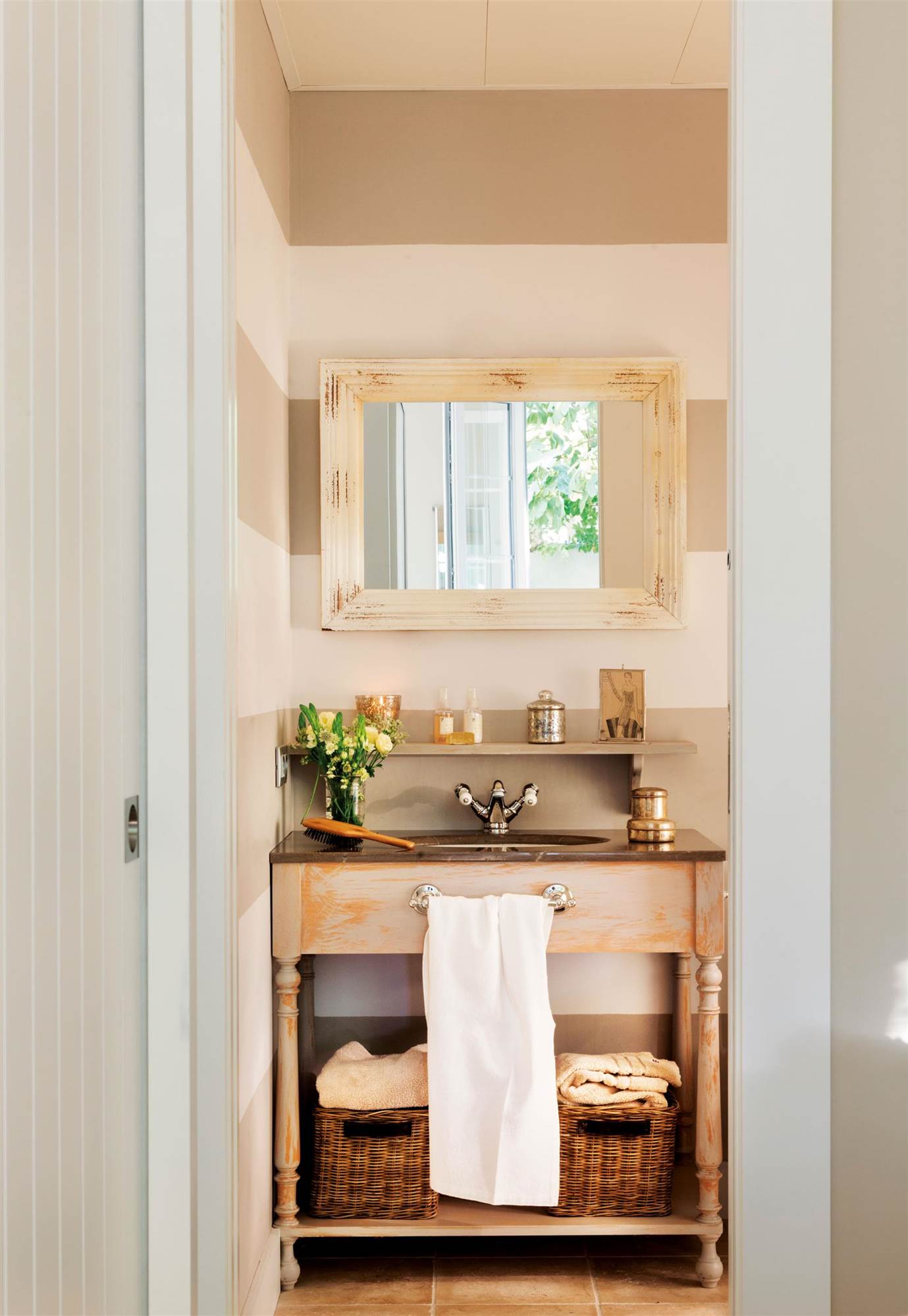 Baño pequeño con mueble de diseño clásico de aspecto enjevecido. Balda con cestas de fibras.