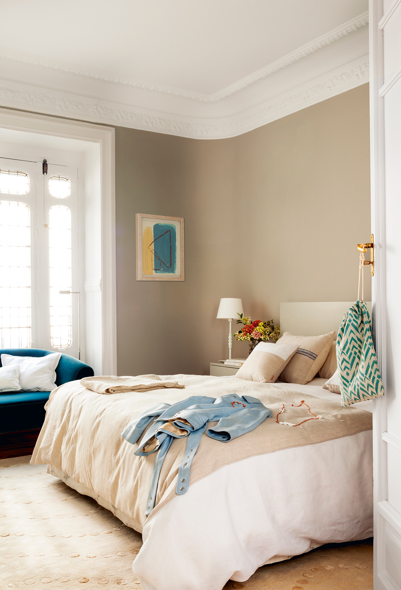 Dormitorio señorial con ventanal y sofá azul
