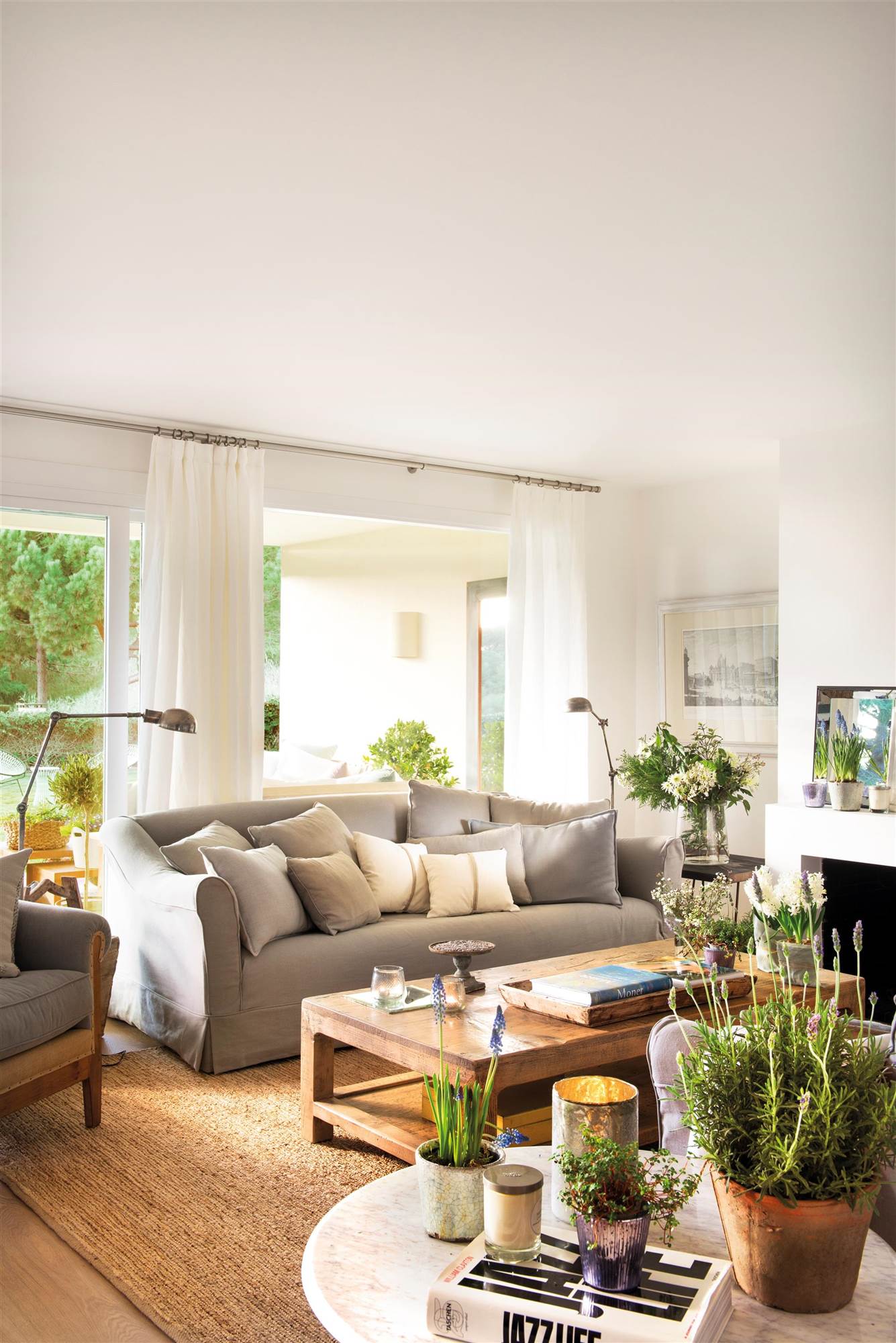 Salón con sofá gris, mesa de centro de madera y alfombra de fibra natural. 