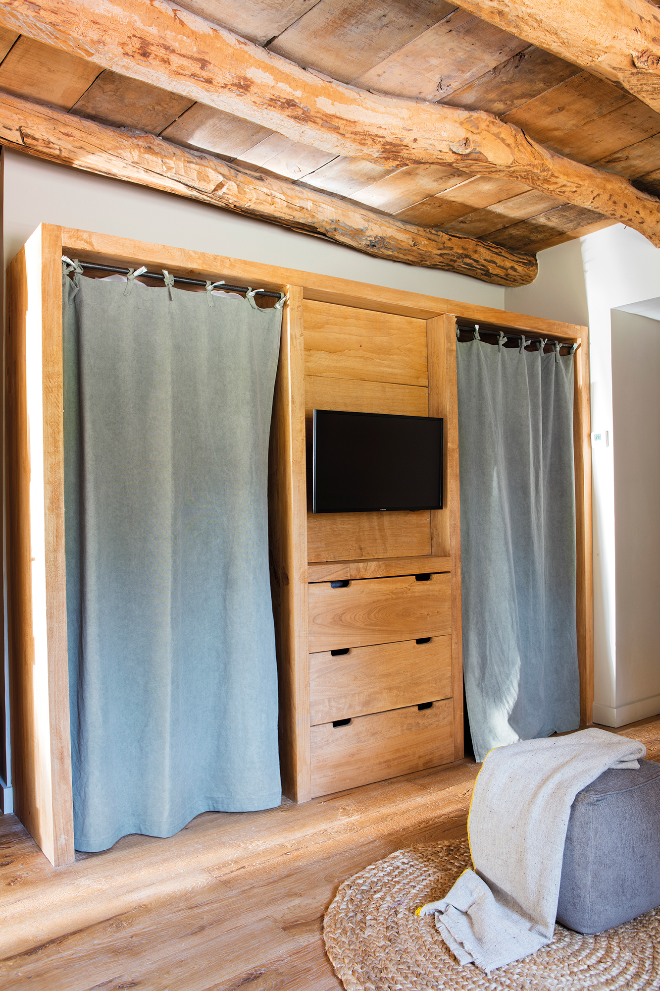 Vestidor rústico con armarios de madera cerrados con cortinas. 
