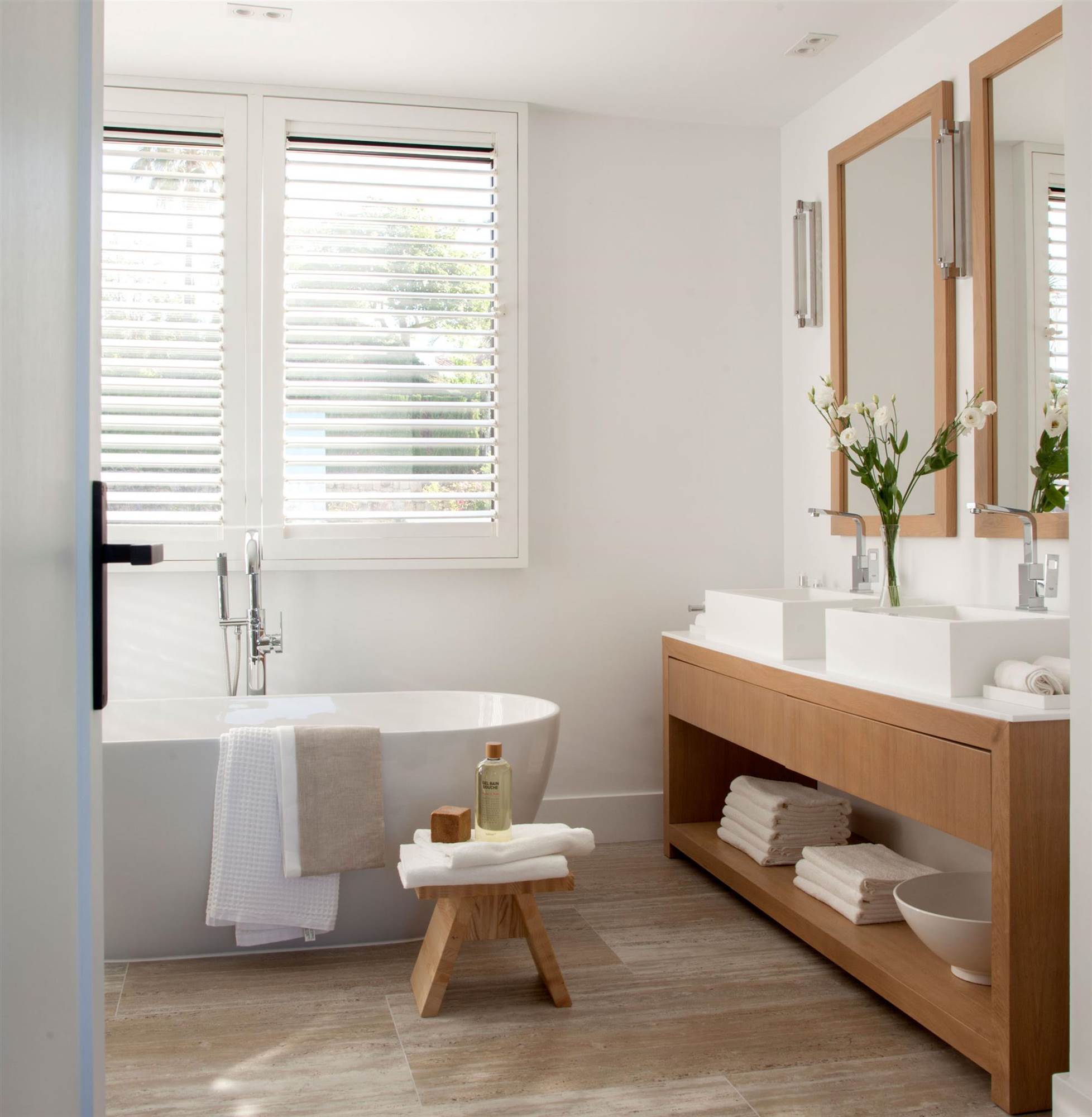 Baño moderno con mueble y espejo con marco de madera.