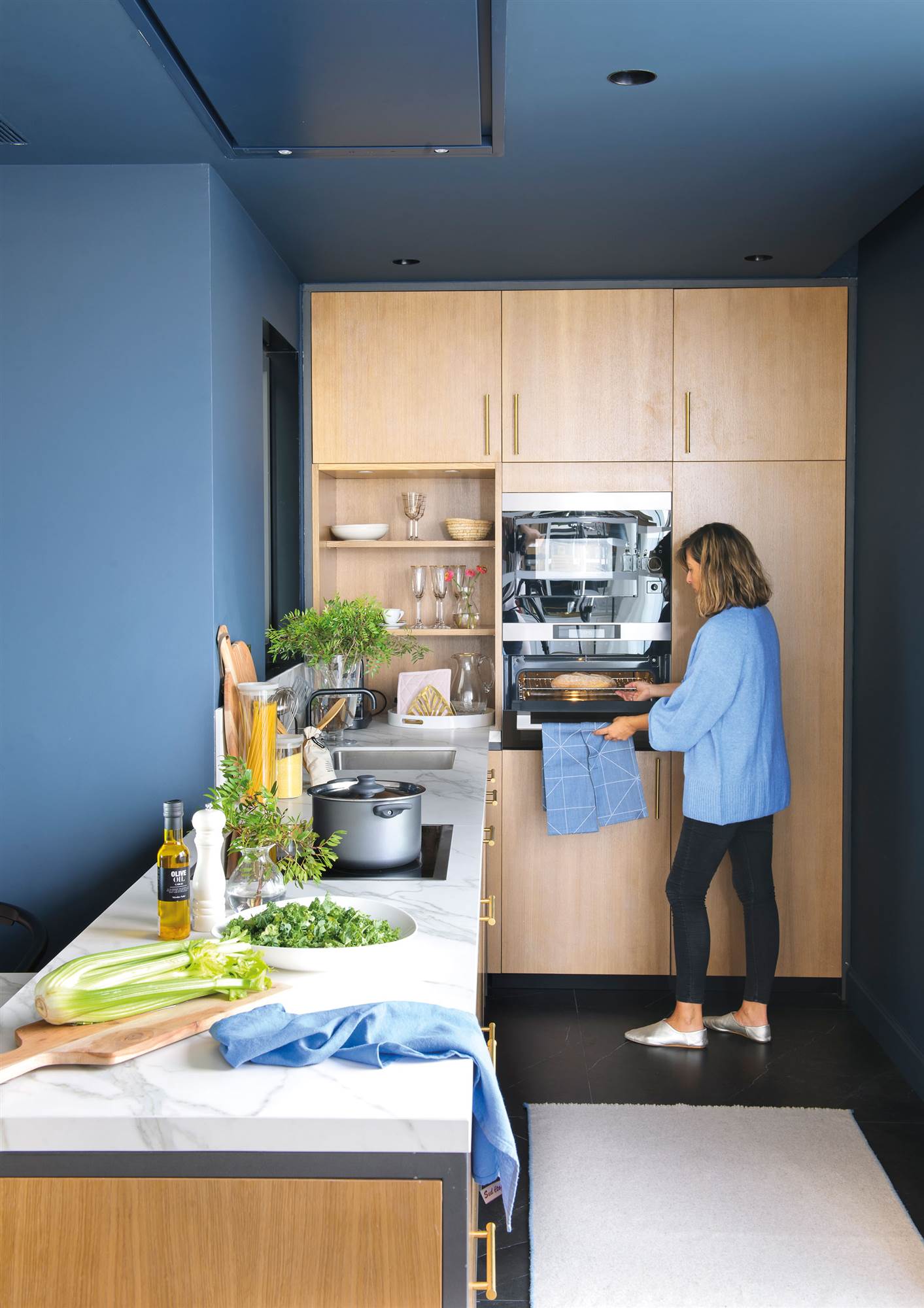 Cocina de madera con paredes y techos de color azul. 