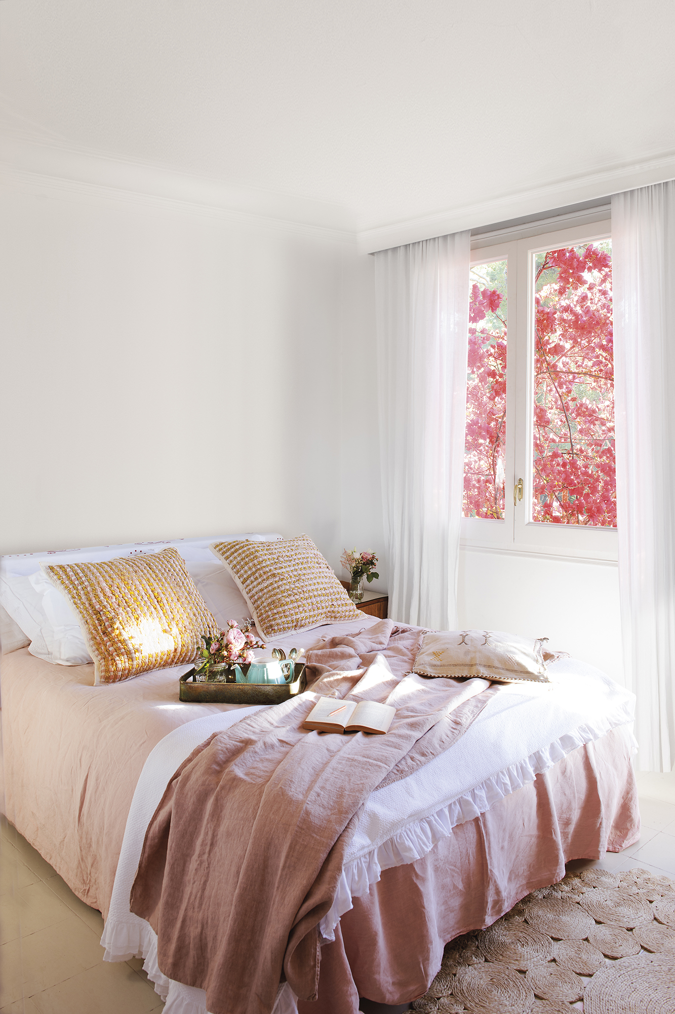 Dormitorio blanco con ropa de cama rosa. 