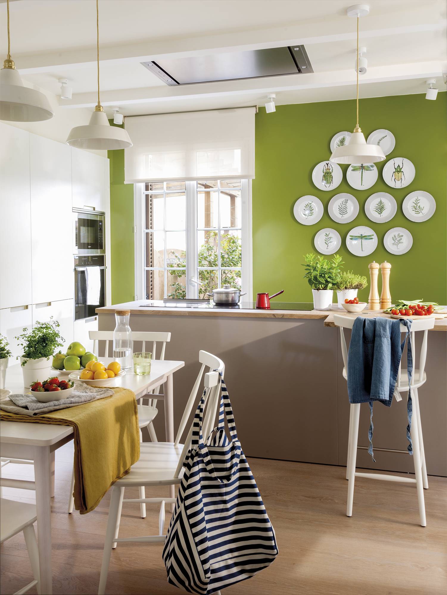 Cocina con isla y pared de color verde.