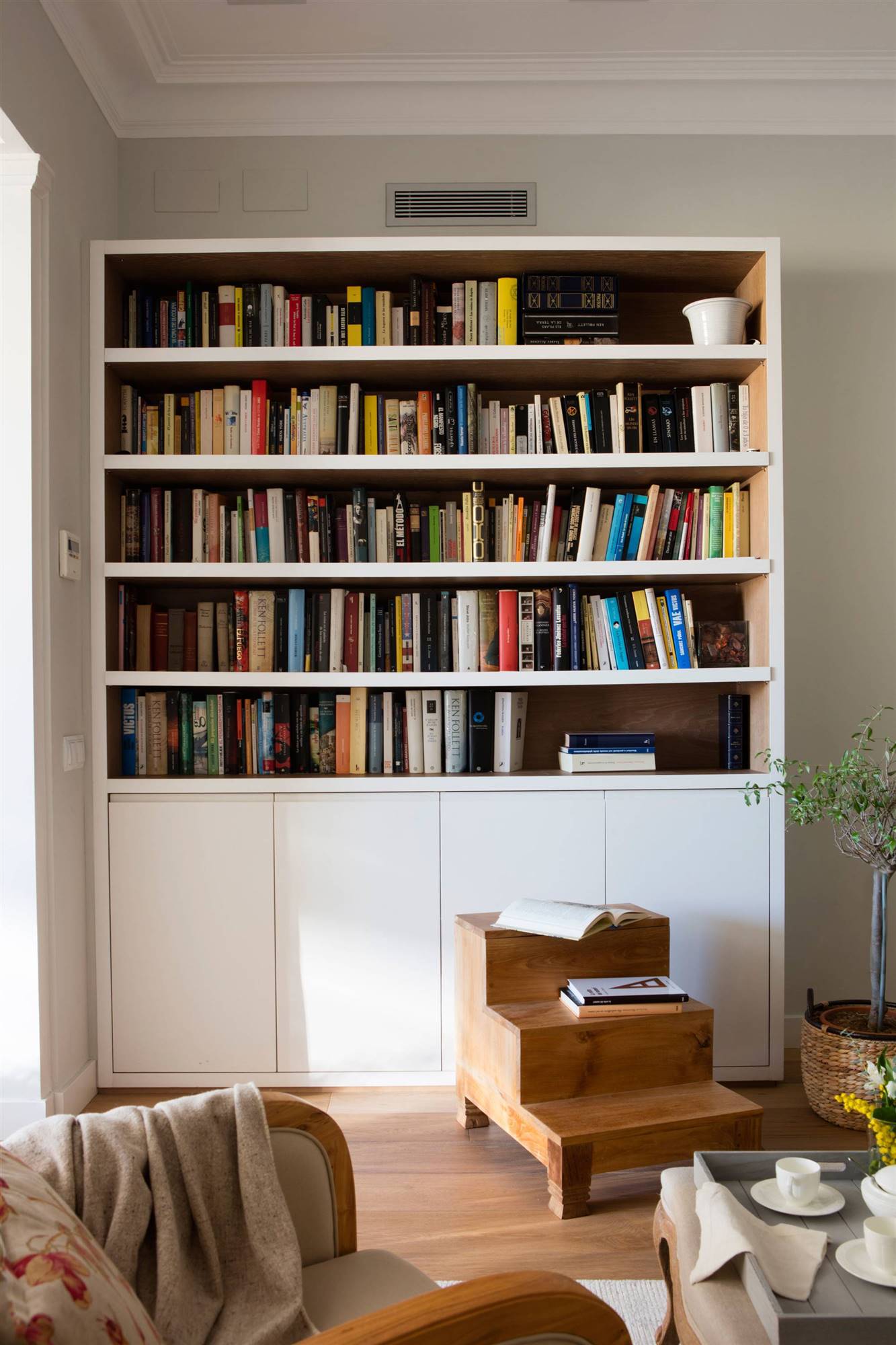 Librería blanca por fuera, madera por dentro.