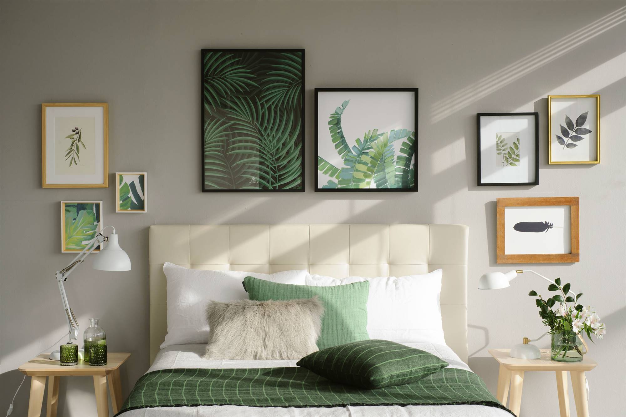 Dormitorio con cabecero decorado con cuadros.