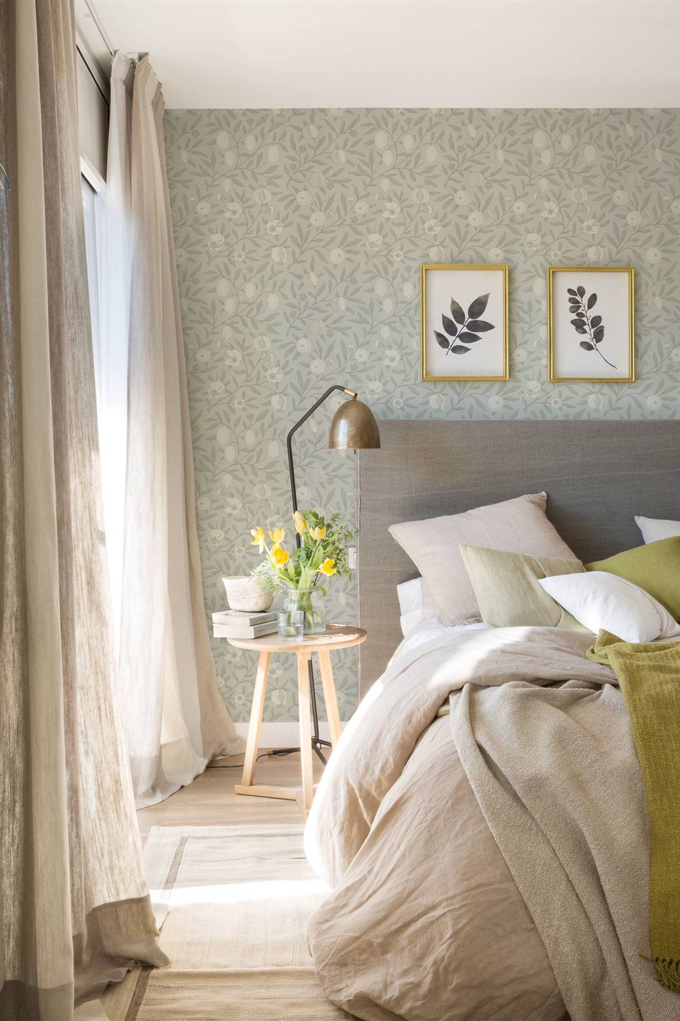 Dormitorio con pared con papel pintado y cama con cabecero. 