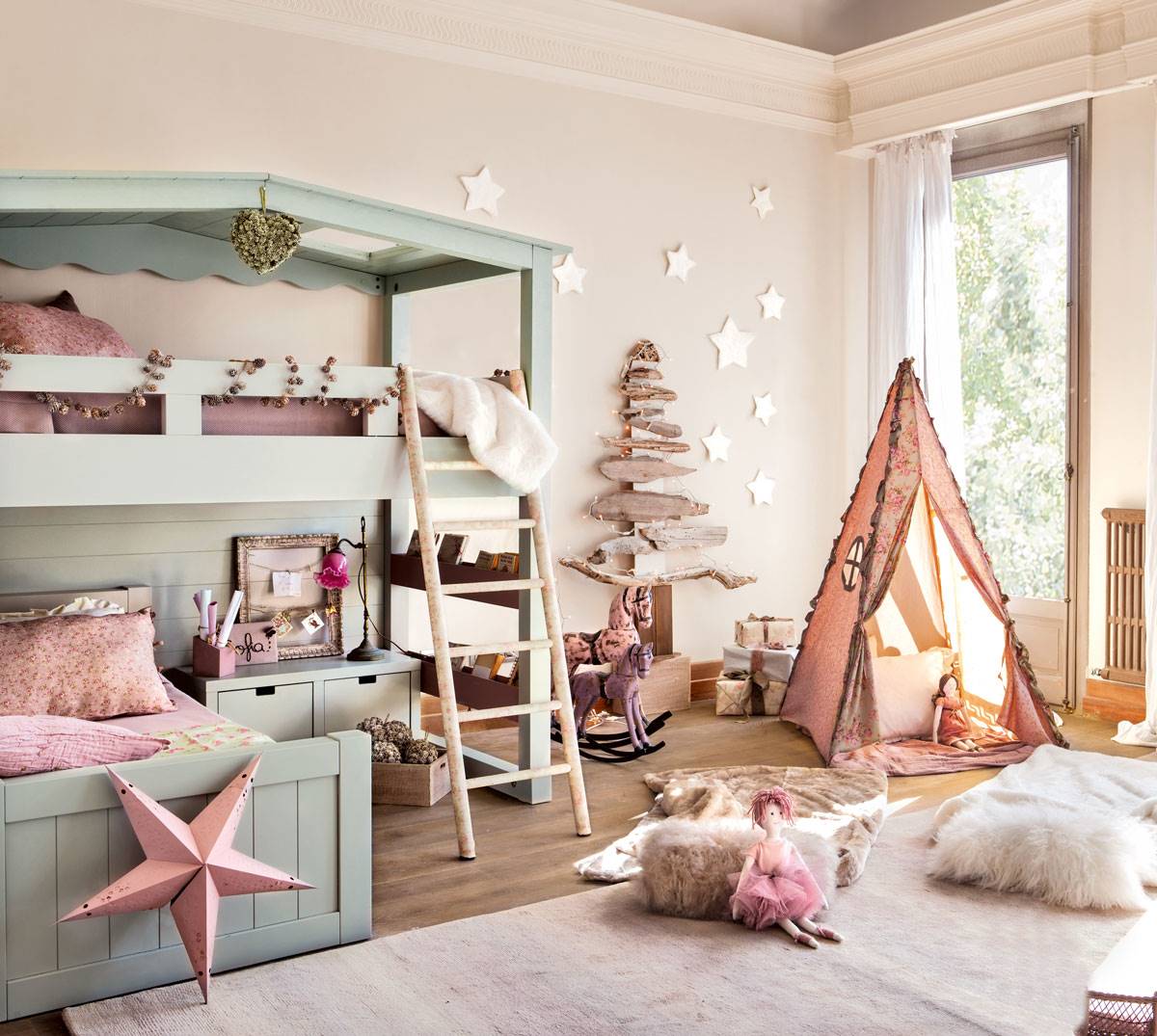 Dormitorio infantil con cama con litera rosa y azul y árbol de Navidad rústico hecho de madera reflotada.