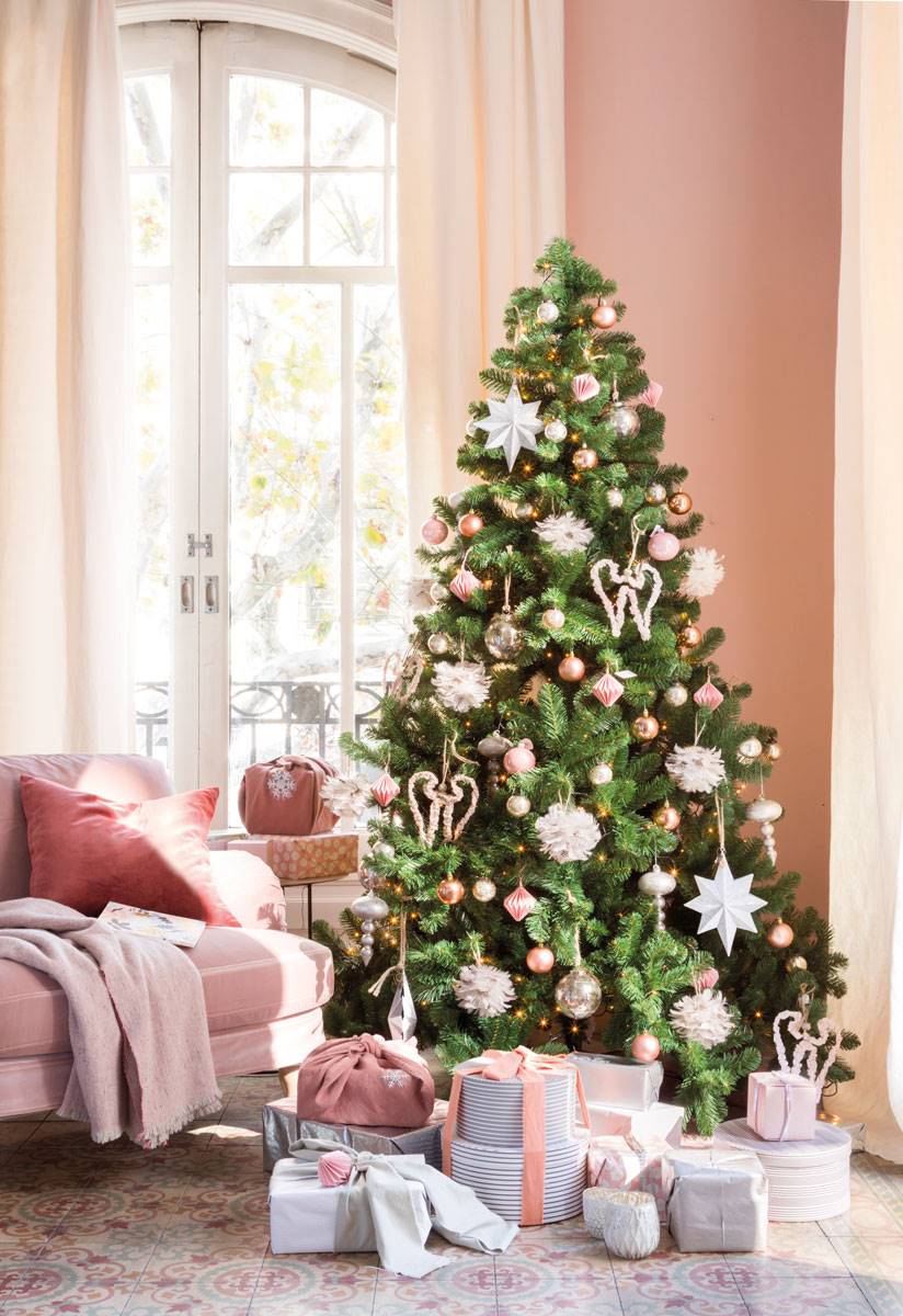 Salón con sofá y árbol de Navidad decorado en rosa y plateado.