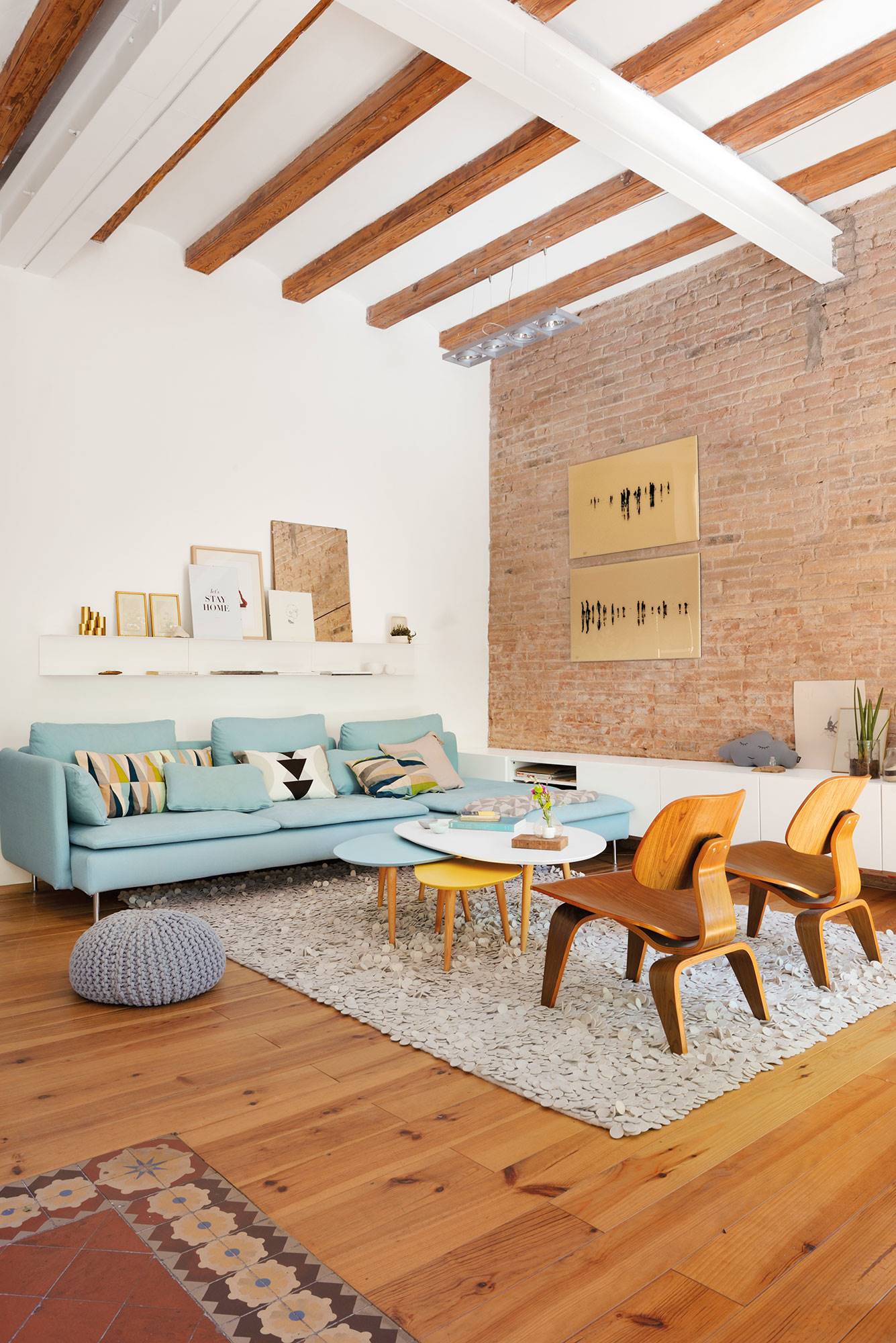 Salón regio con sofá azul y butacas de madera de diseño.
