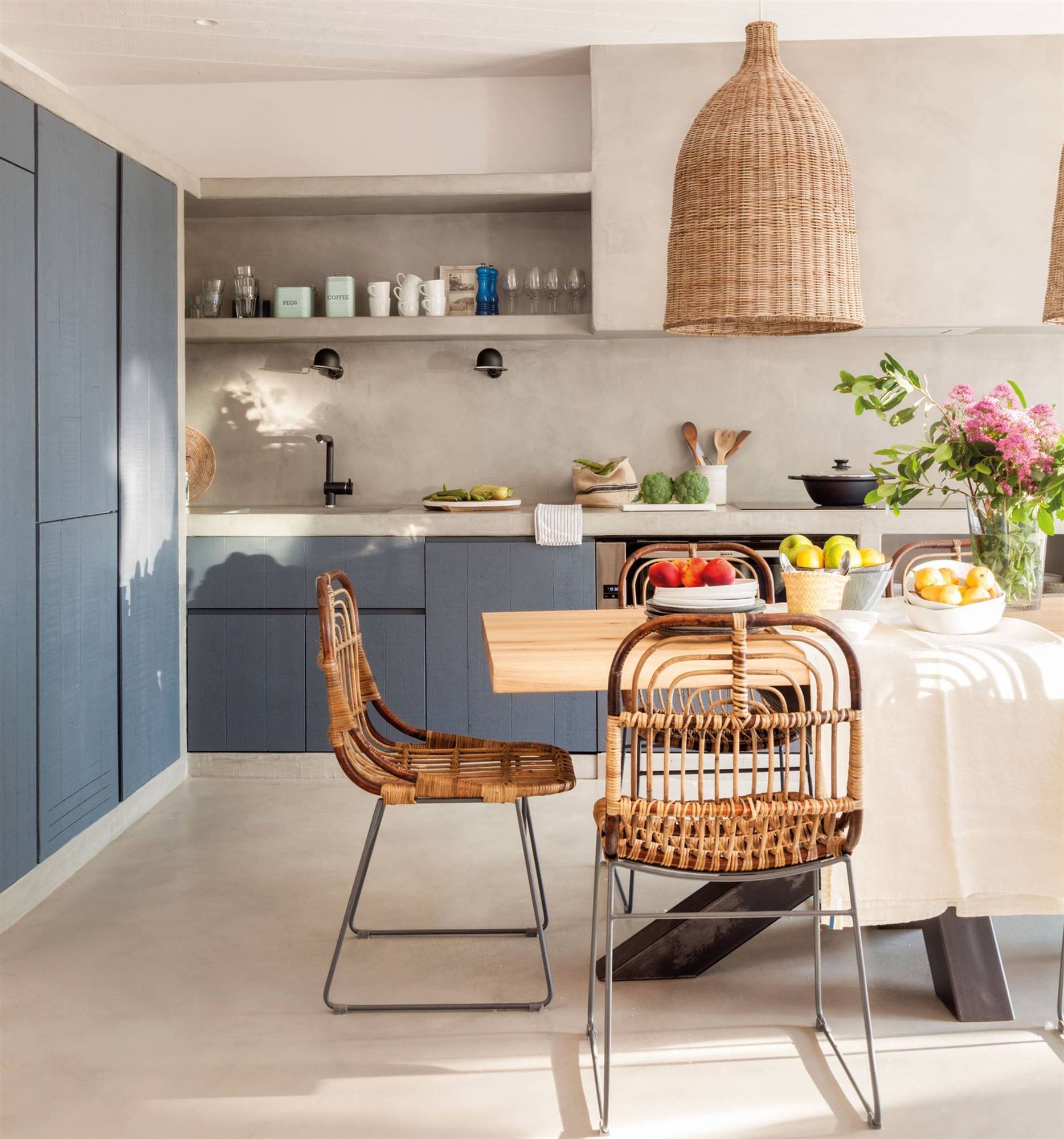 Moderna cocina con mobiliario en color azul y detalles de fibras naturales.