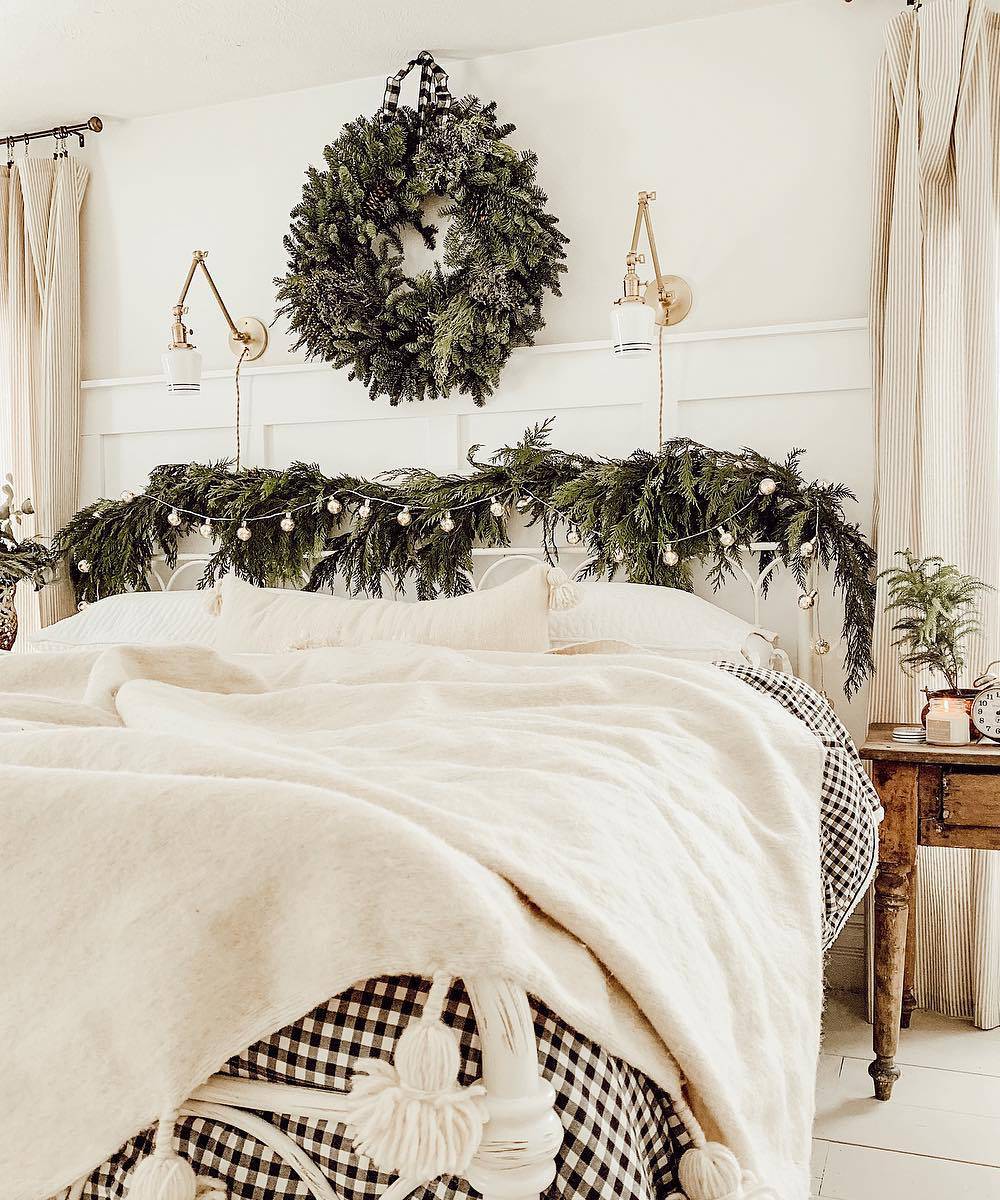 Corona de Navidad frondosa encima de la cama.