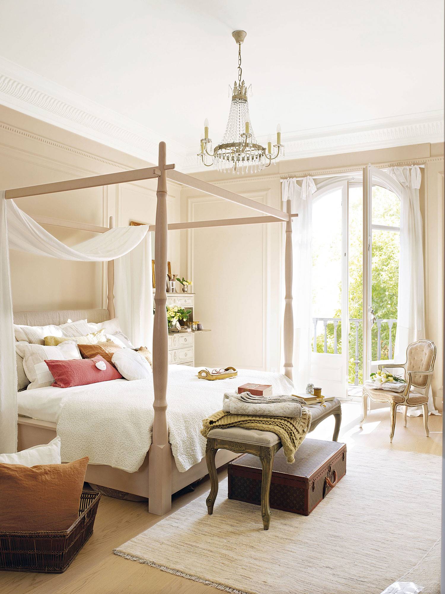 Dormitorio con cama con dosel y lámpara de araña. 