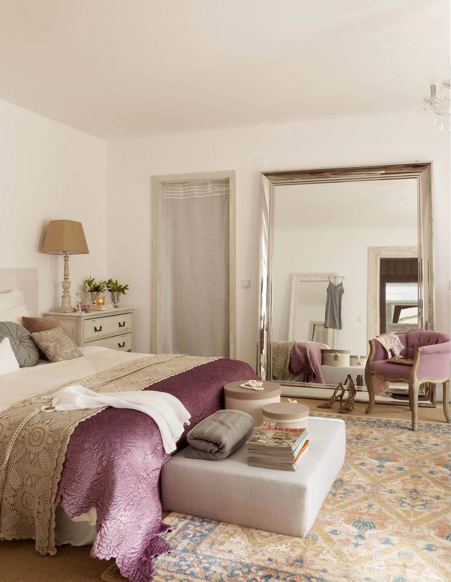 Dormitorio con alfombra kilim y colcha morada. 