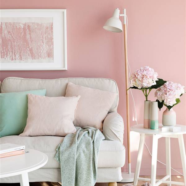 Semitoma de salón con pared rosa, cojines rosas