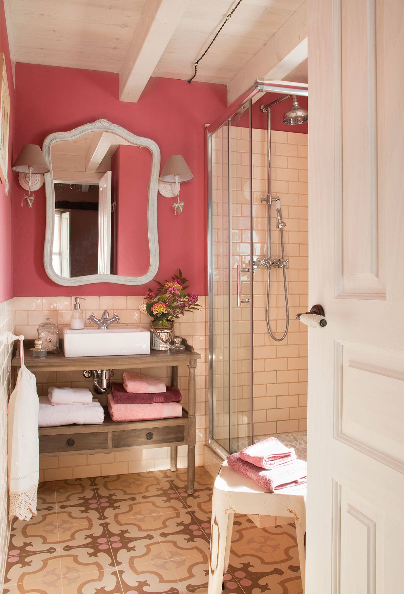Baño con paredes rosas y azulejos tipo metro. 